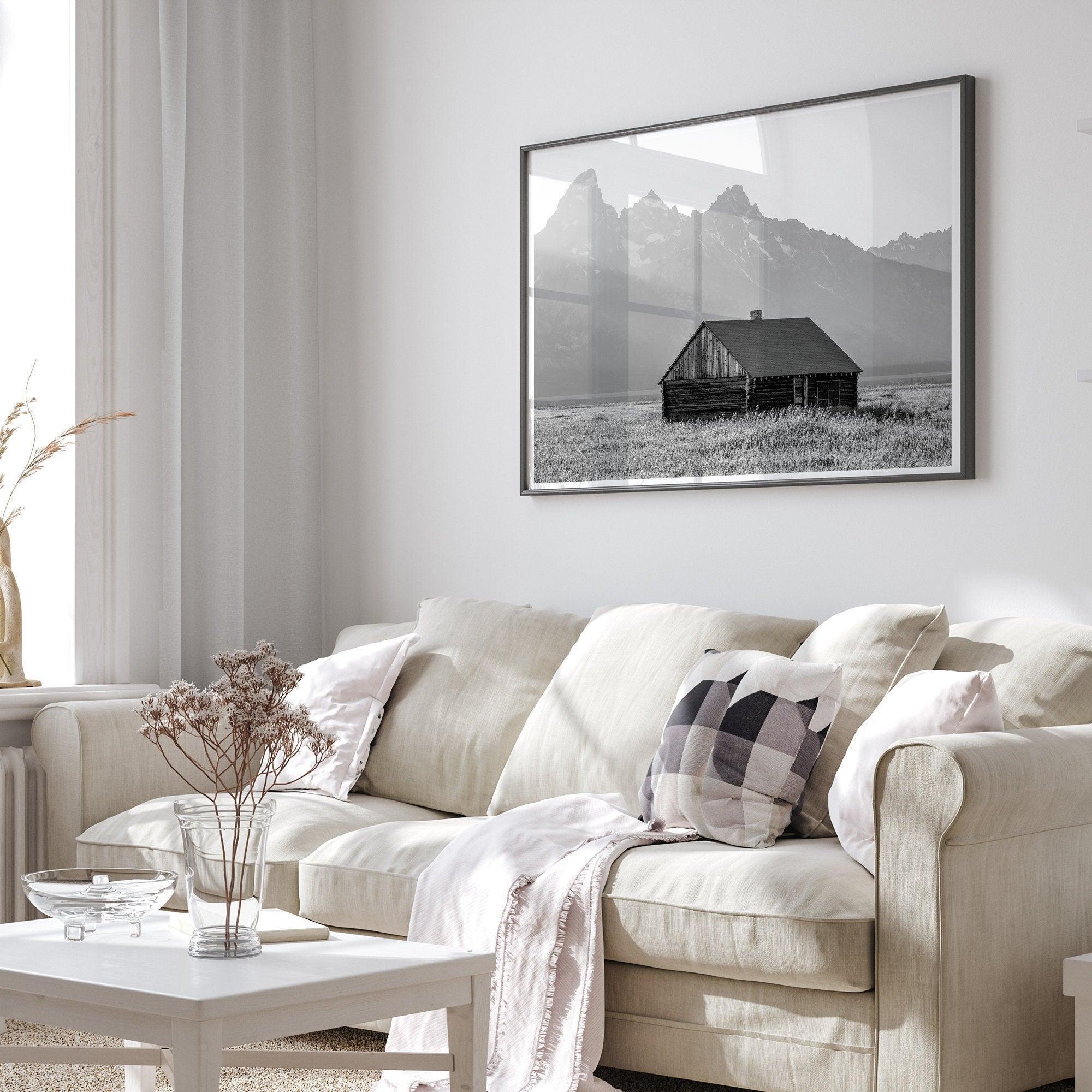 Step into Grand Teton National Park with this fine art black and white mountain print. This western landscape photo showcases a century-old rustic hut at the foot of the snowy, pointy Teton mountains.