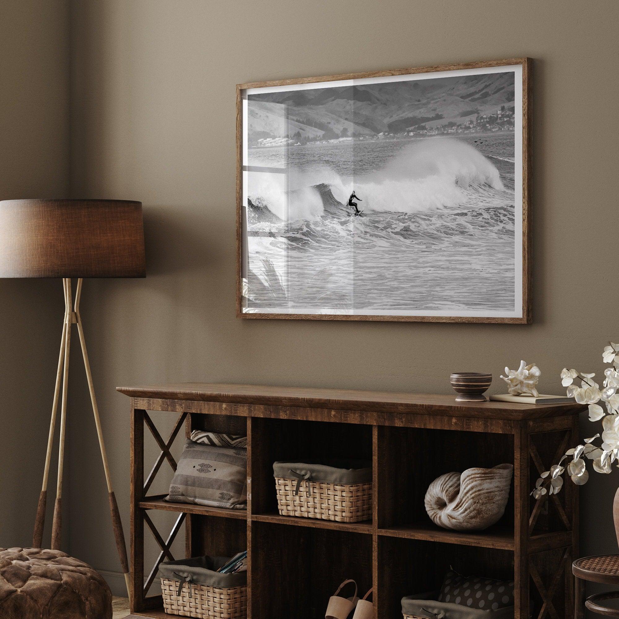 A black and white fine art surf print. This ocean wall art showcases a lone surfer riding the waves in Pismo Beach, California.