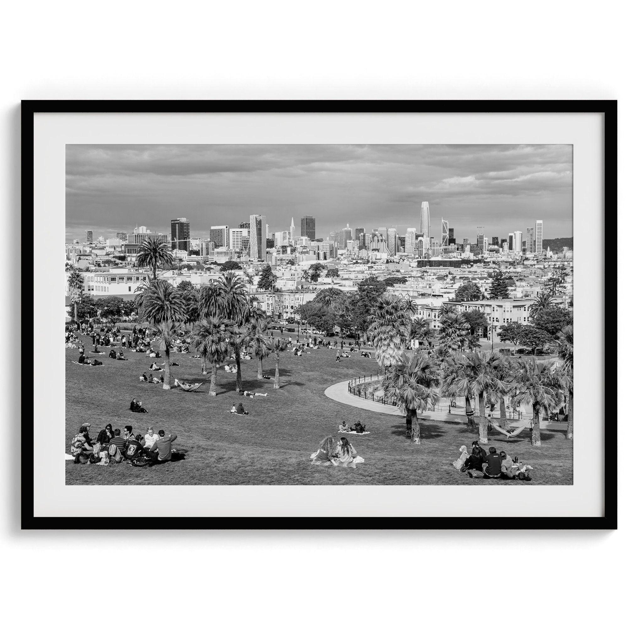 Black and white fine art print of Mission Dolores Park in San Francisco showcasing picnic blankets and people enjoying a quiet afternoon with the city skyline in the backdrop.