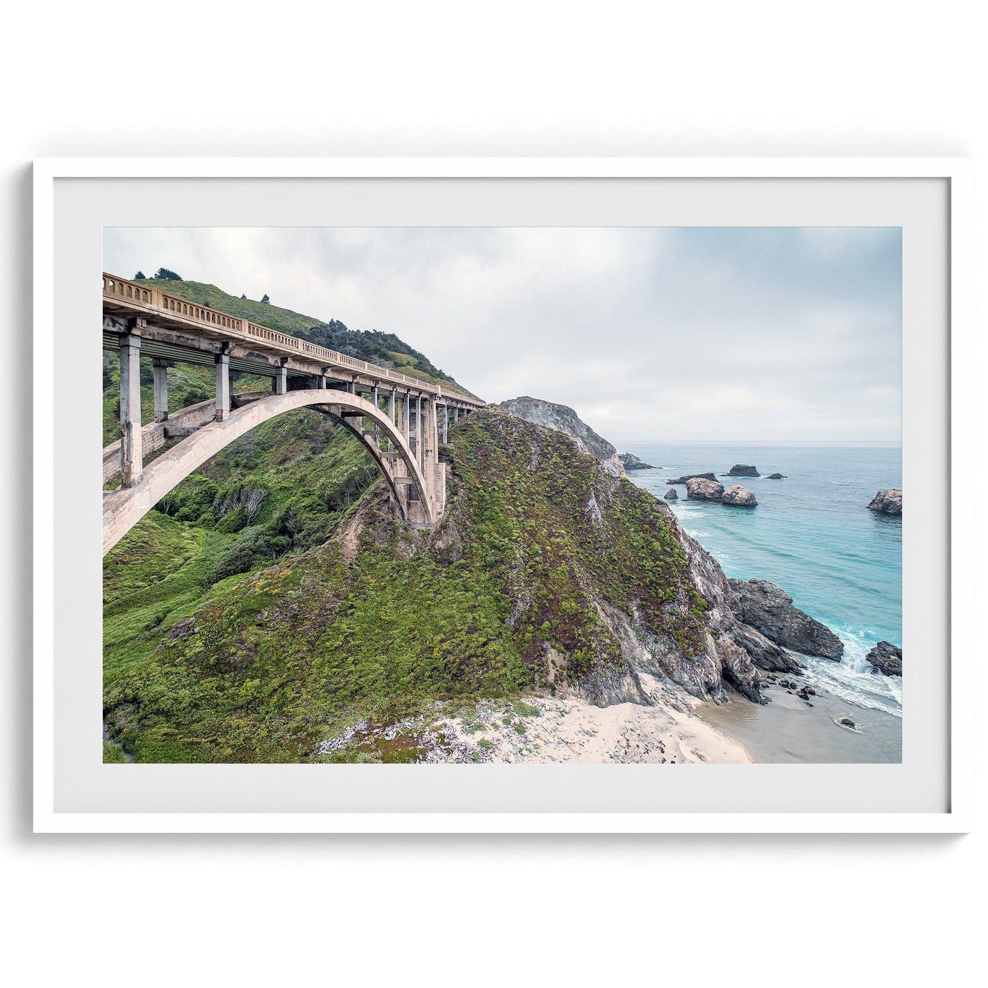 A fine art ocean print of one of the most iconic spots in the famous Route 1 in California - Bixby Bridge near Big Sur. Shot in a unique wide angle that captures the bridge, cliffs, the ocean, and the stunning beach below.