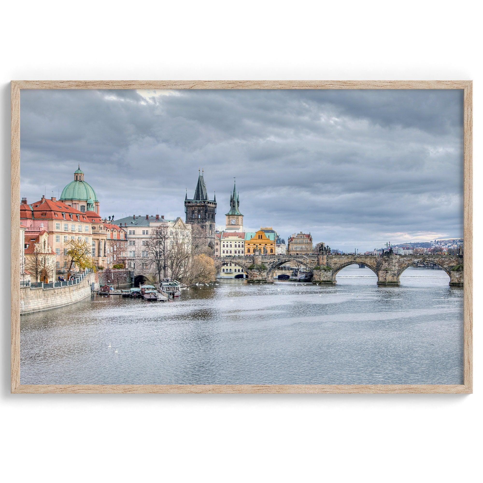 This Prague wall art is a fine art photography print of Charles Bridge against a moody skyline, evoking an old-world painting. Timeless allure captured on archival paper, available in various sizes and frames.