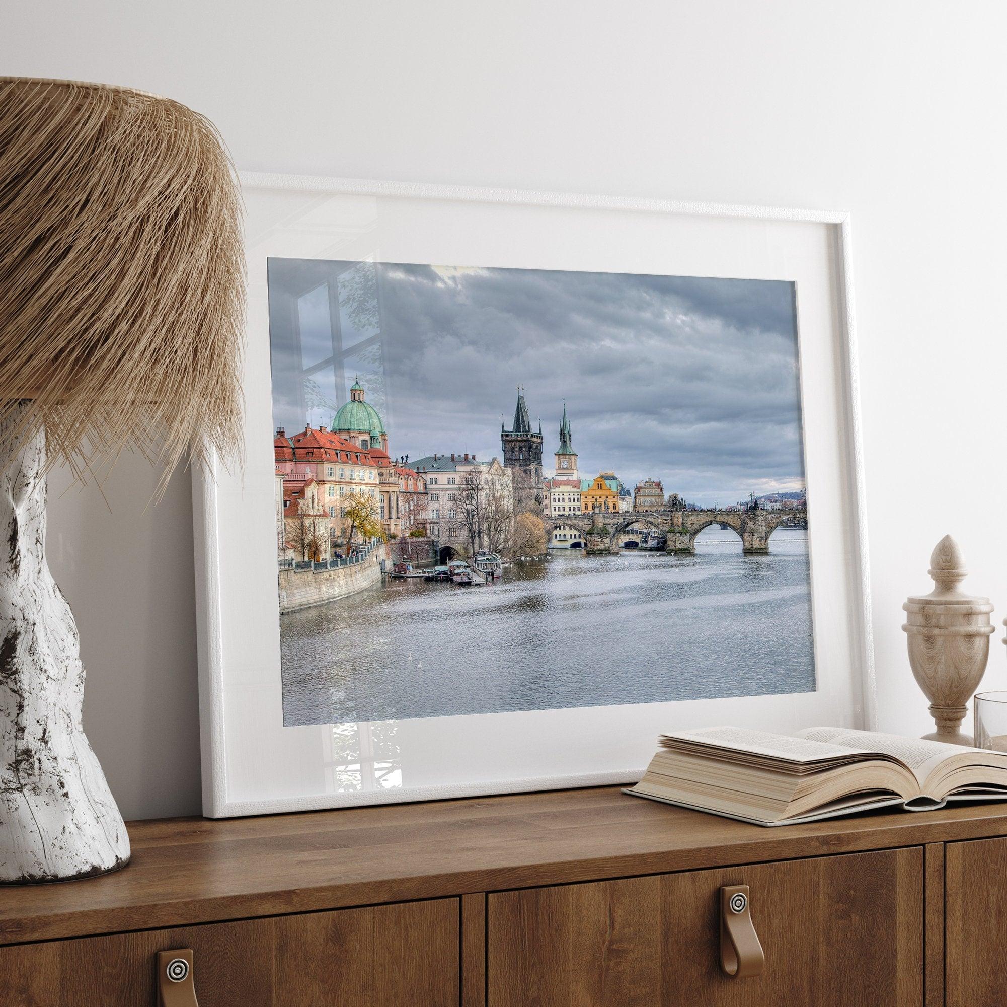 This Prague wall art is a fine art photography print of Charles Bridge against a moody skyline, evoking an old-world painting. Timeless allure captured on archival paper, available in various sizes and frames.