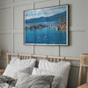 A fine art Lake Tahoe print showcasing a lone stand-up paddle peacefully gliding across the clear water lake near the huge rocks of Sand Harbor Beach with the backdrop of the Sierra Nevada mountains.