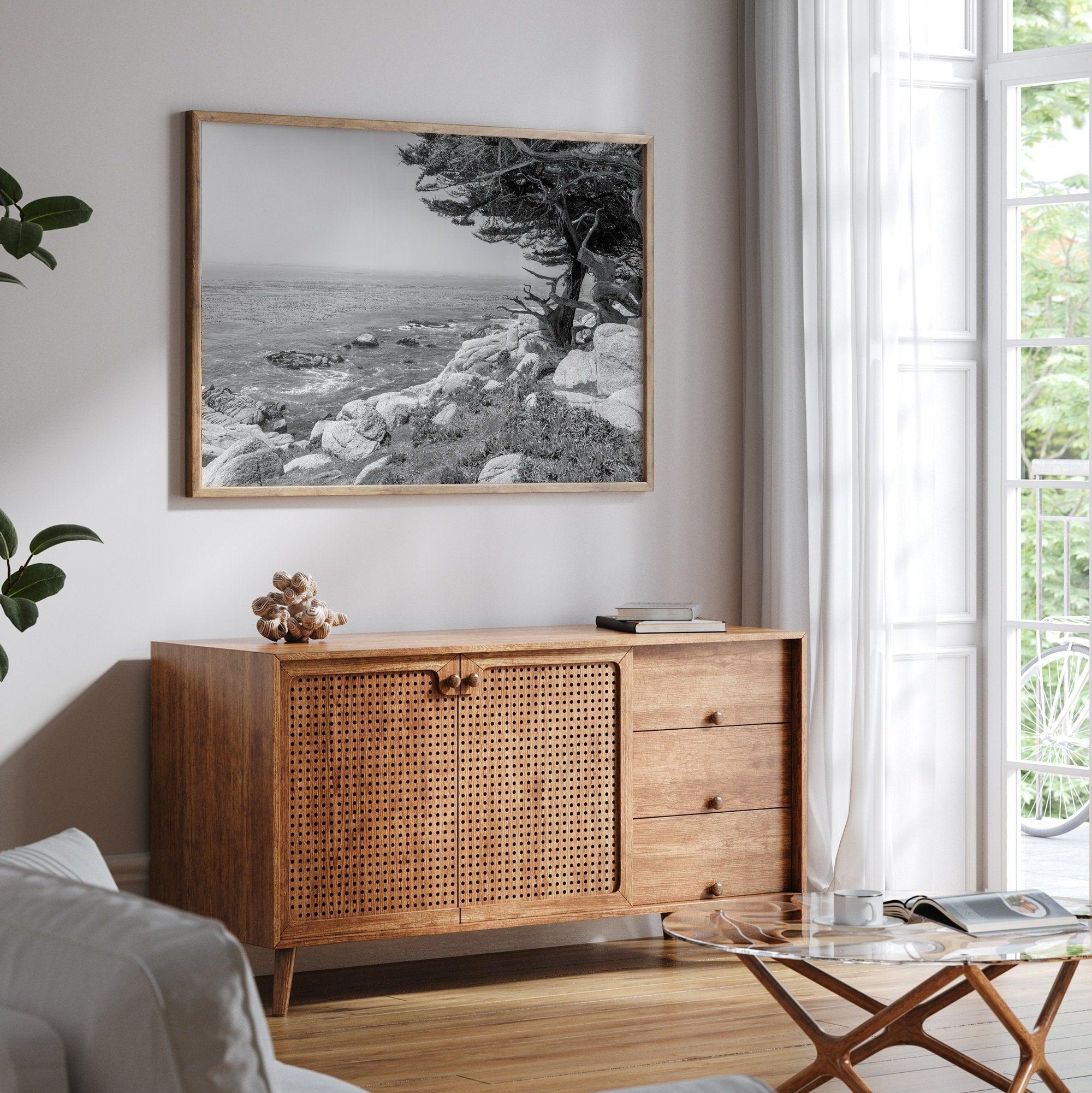 A framed or unframed coastal fine art photography print of a huge cypress tree overlooking the ocean. This black-and-white wall art shows the California rugged coastline in all its glory. Get this Ocean wall decor piece today.