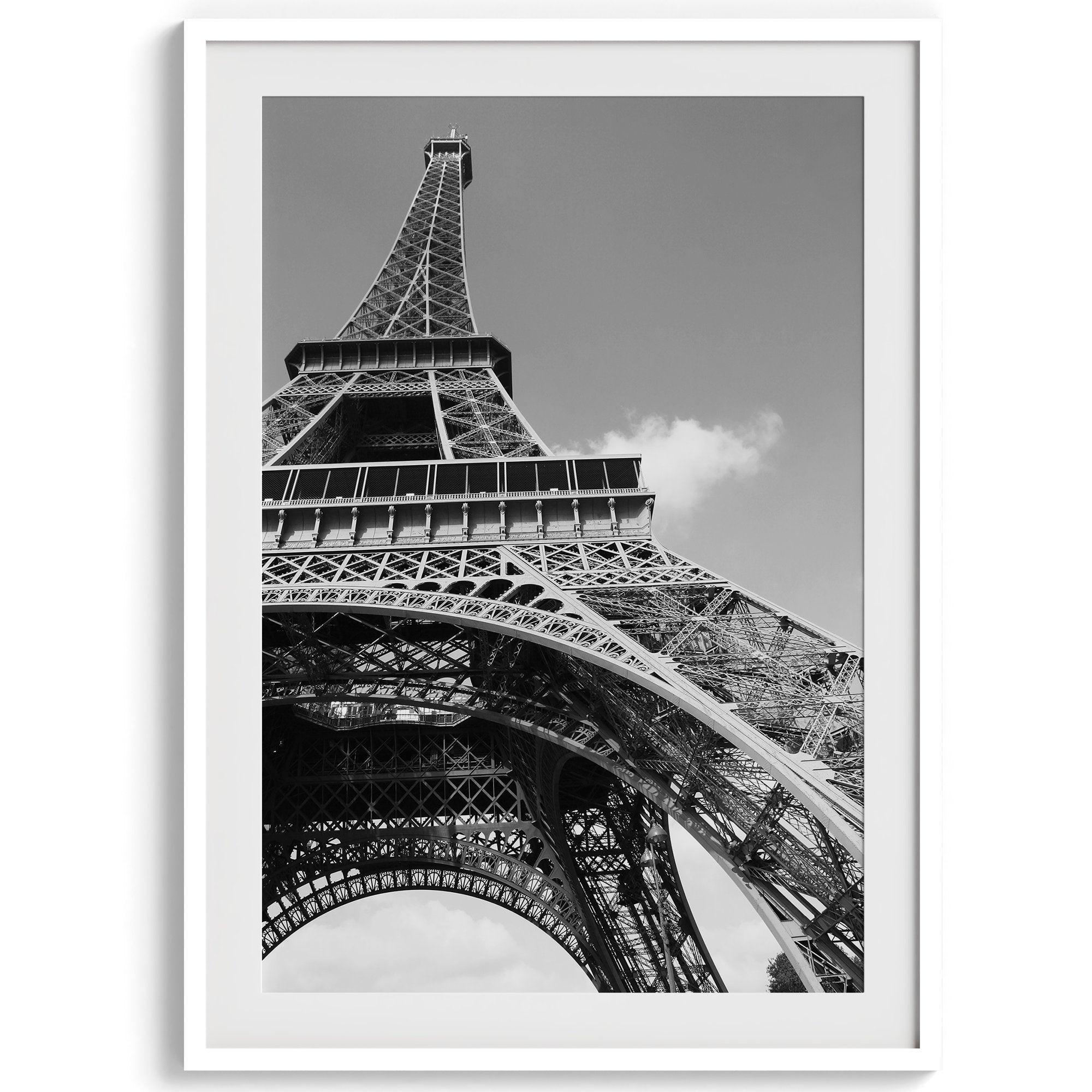 A fine art Eiffel Tower black and white print. This Paris theme wall art showcases a unique wide-angle view from the bottom of the tower, creating a modern, trendy fine art photography to hang on your walls.