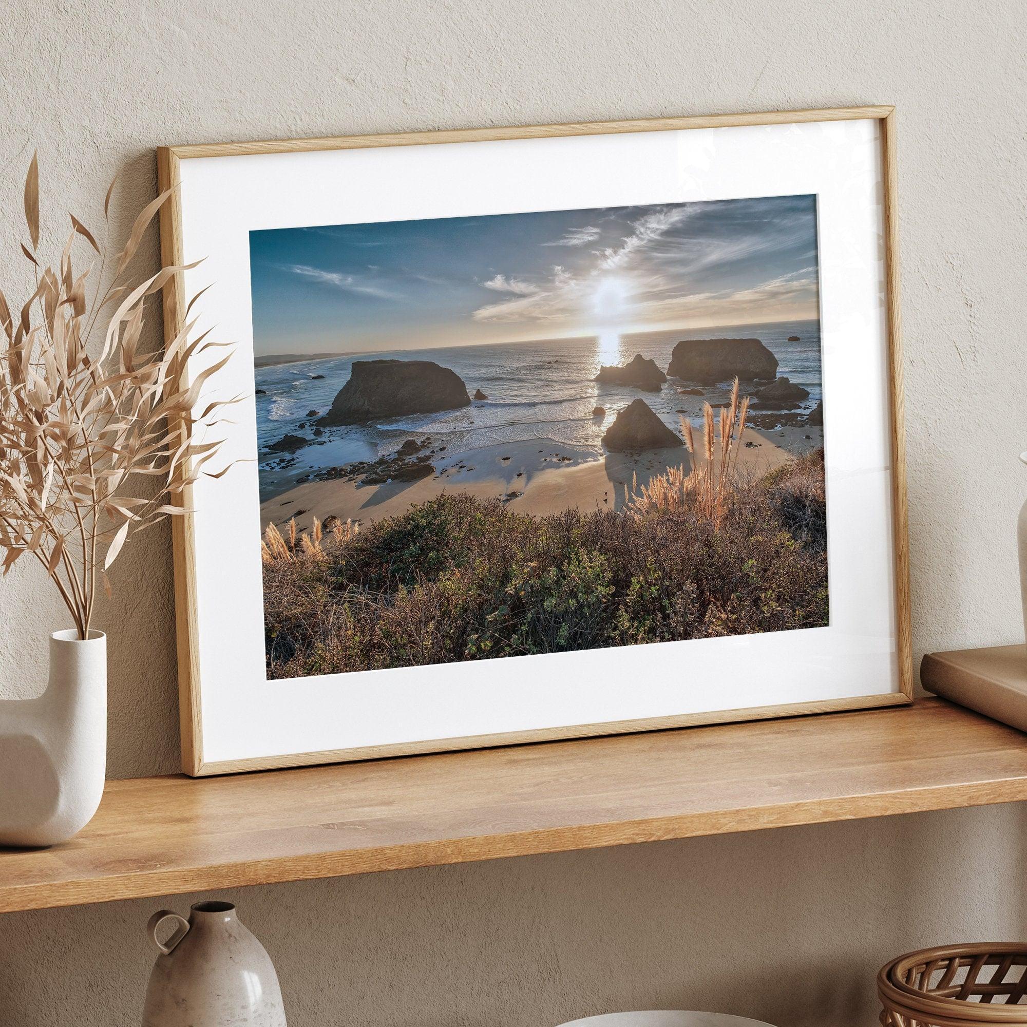 A fine art unframed or framed beach print showing the breathtaking beach of Fort Bragg, California, as the sunset ray of lights hits the ocean and the vast sea stacks.