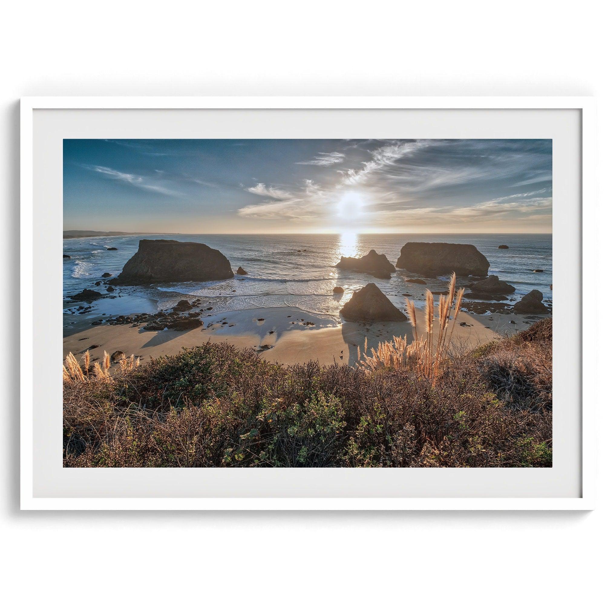 A fine art unframed or framed beach print showing the breathtaking beach of Fort Bragg, California, as the sunset ray of lights hits the ocean and the vast sea stacks.