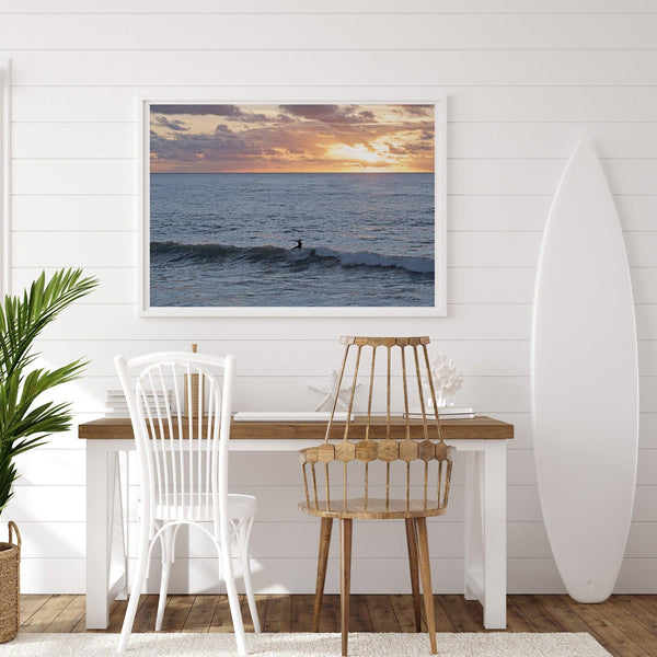 A fine art ocean sunset print showcasing a serene sunset and a lone surfer riding the waves. Taken in Montana De Oro State Park, California.