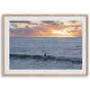 A fine art ocean sunset print showcasing a serene sunset and a lone surfer riding the waves. Taken in Montana De Oro State Park, California.
