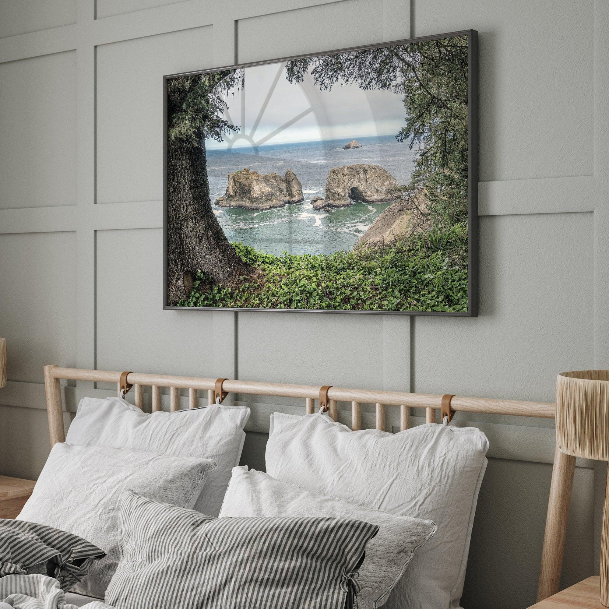 This stunning coastal photo was taken in Samuel H. Boardman State Scenic Corridor in Oregon. This ocean wall art shows unique rock formations in a vast blue Pacific Ocean through a window created from coastal trees and plants.