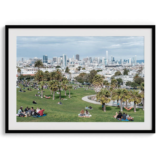 A fine art unframed or framed San Francisco print of Mission Dolores Park showcasing picnic blankets and people enjoying a quiet afternoon with the city skyline in the backdrop.