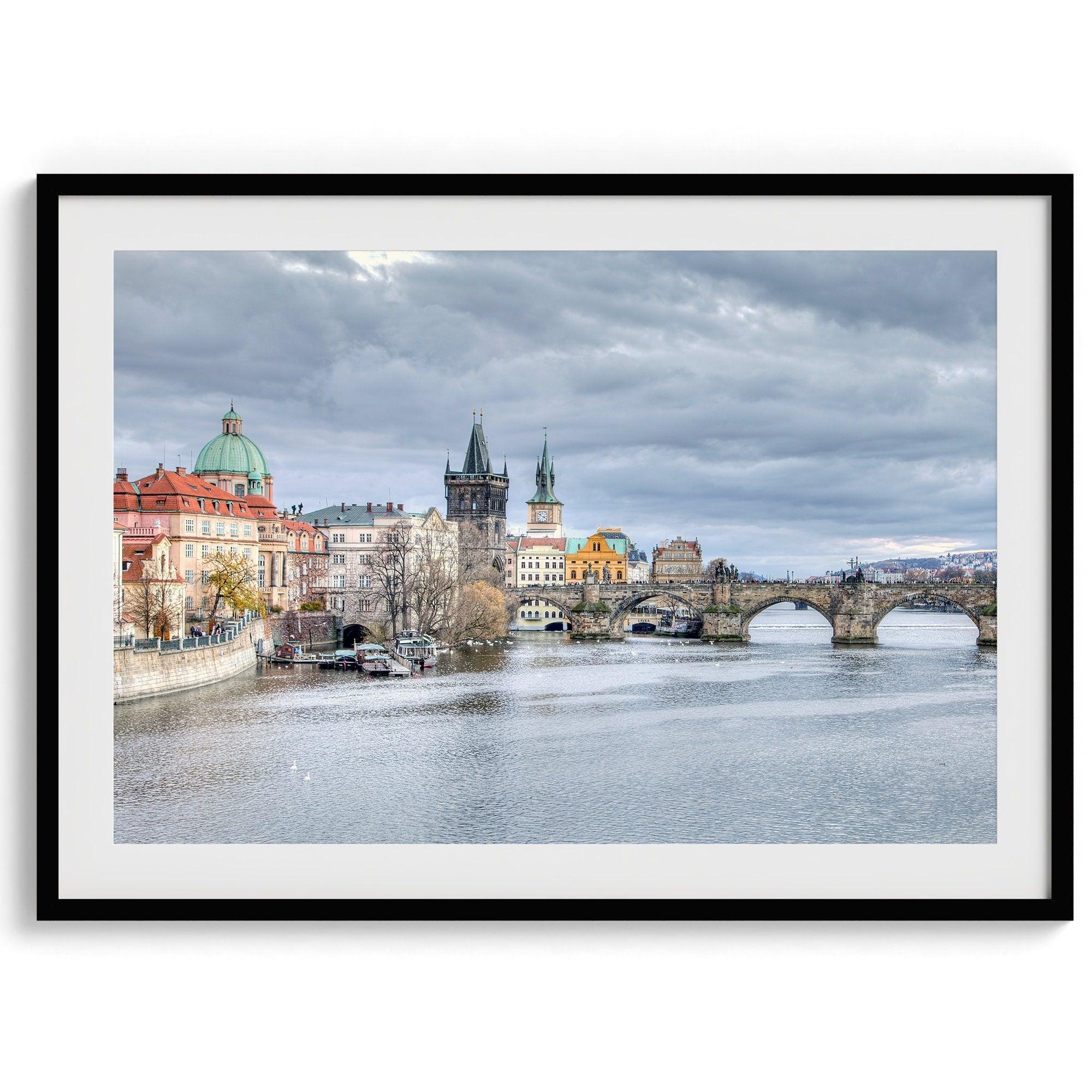 This Prague wall art is a fine art photography print of Charles Bridge against a moody skyline, evoking an old-world painting. Timeless allure captured on archival paper, available in various sizes and frames.