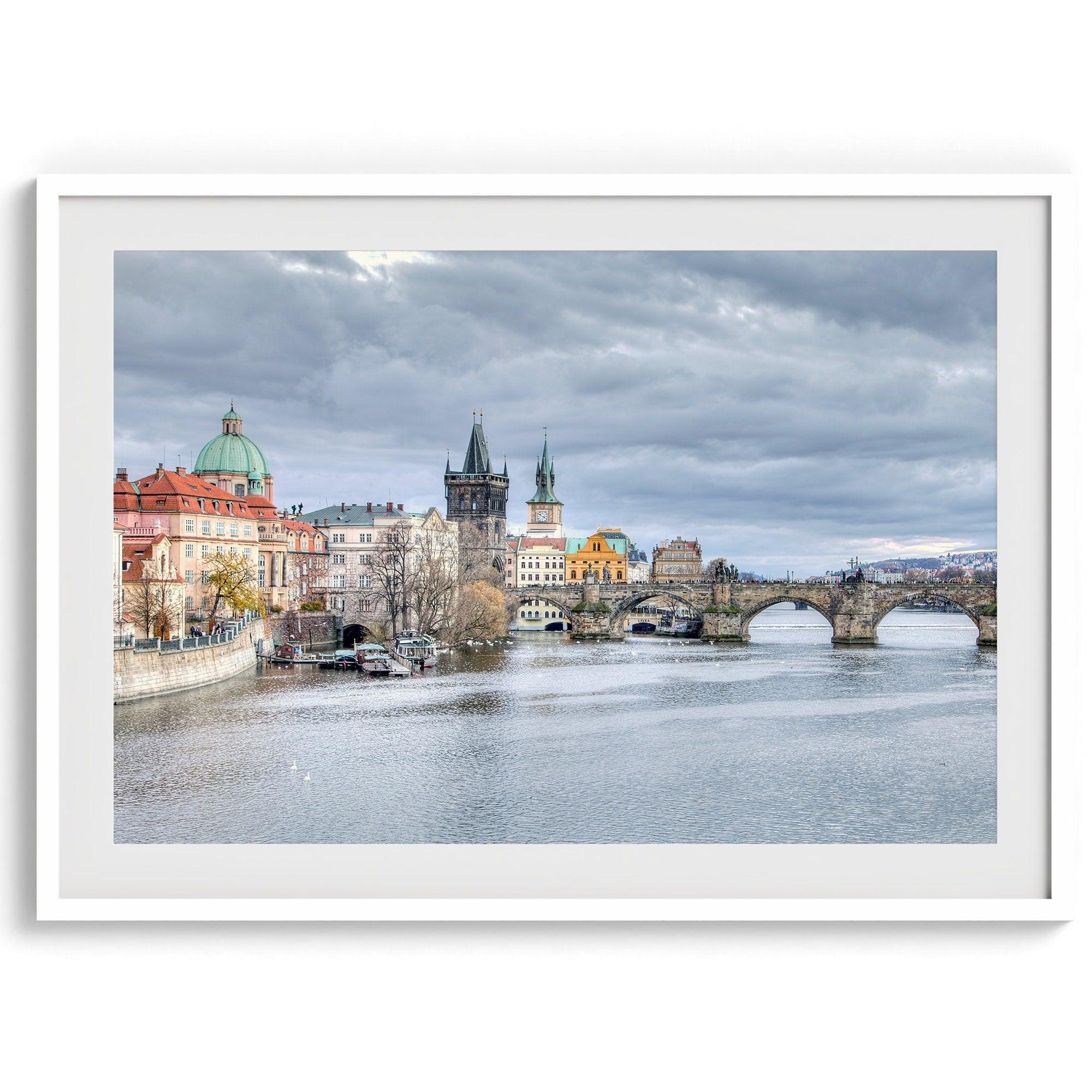 This Prague wall art is a fine art photography print of Charles Bridge against a moody skyline, evoking an old-world painting. Timeless allure captured on archival paper, available in various sizes and frames.