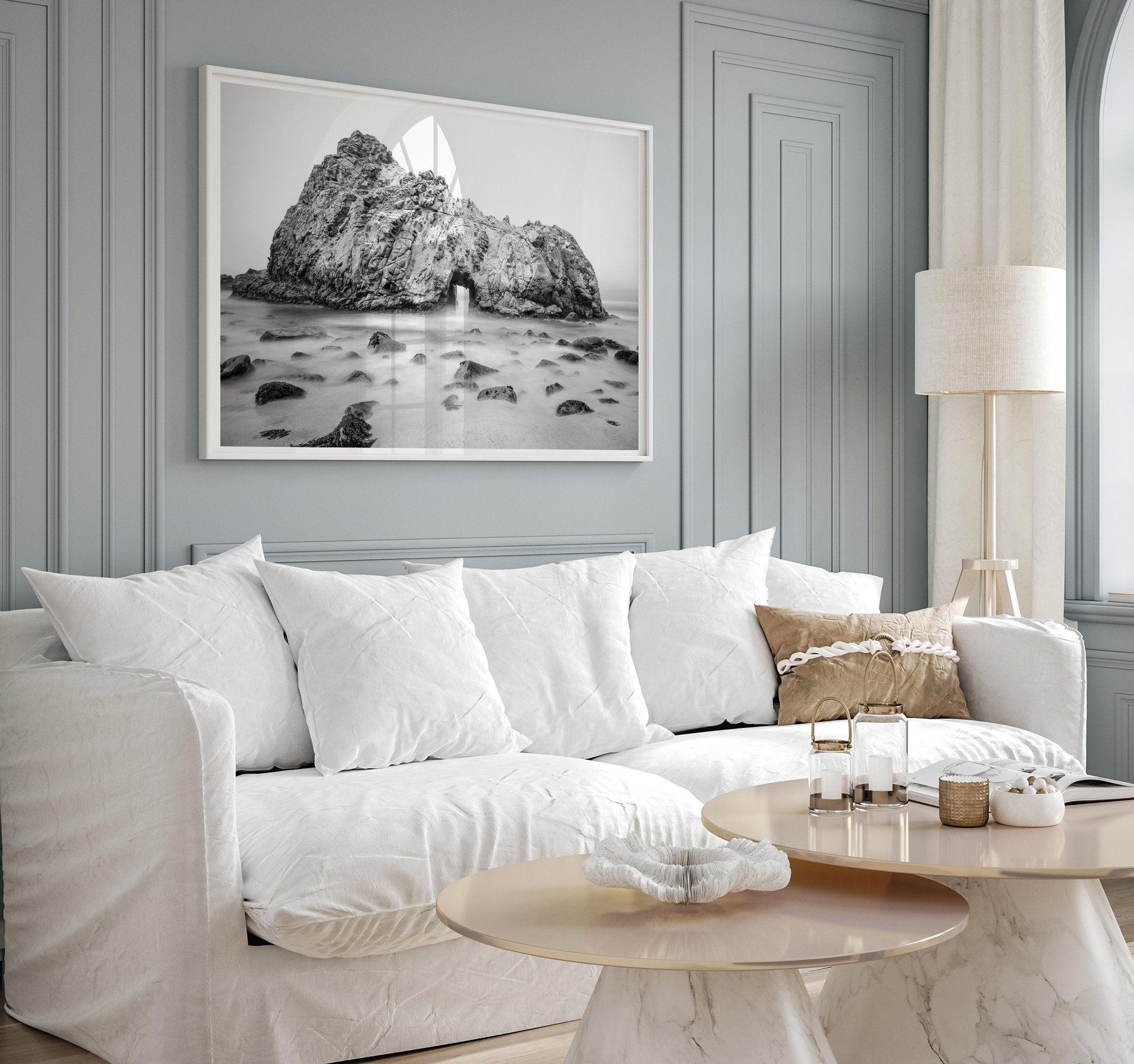 A fine art black and white print of Big Sur Pfeiffer Beach. This beach wall art shows a huge rock on the beach with an opening towards the open sea. This fine art photograph is shot in long exposure so the waves look creamy, gliding over the rocks