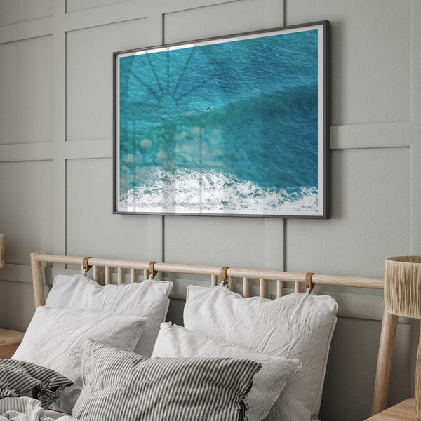 A fine art ocean print of an aerial beach showing a lone surfer with a large wave underneath.
