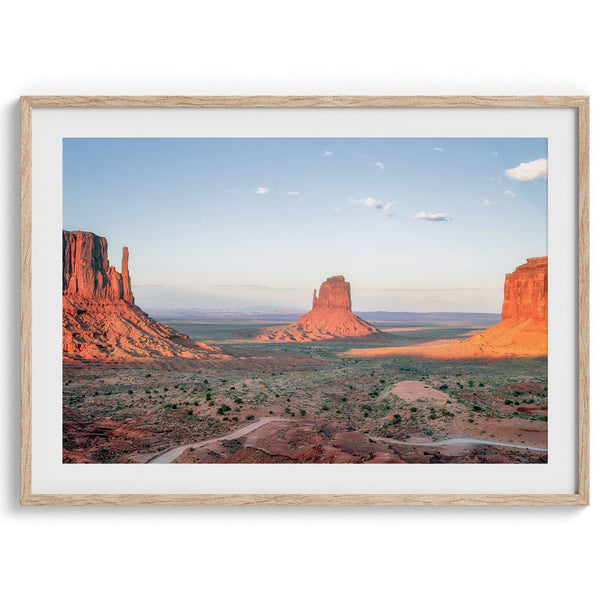 A fine art landscape photography print of a desert sunset over Monument Valley, located on the Arizona-Utah border. The warm and vibrant hues of this American Southwest sunset create a mesmerizing and awe-inspiring scene.