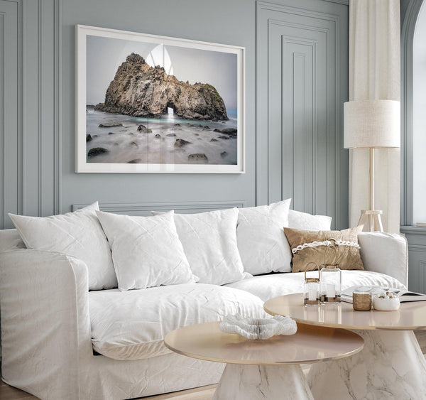 Fine art print showcasing a magnificent rock formation framing the horizon and crashing waves, with scattered rocks adding texture. Captivating and soothing, this print is a timeless addition to any space, evoking relaxation and awe-inspiring beauty.
