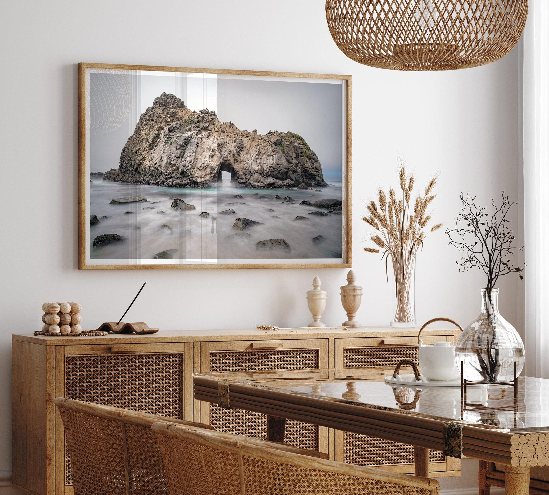 Fine art print showcasing a magnificent rock formation framing the horizon and crashing waves, with scattered rocks adding texture. Captivating and soothing, this print is a timeless addition to any space, evoking relaxation and awe-inspiring beauty.