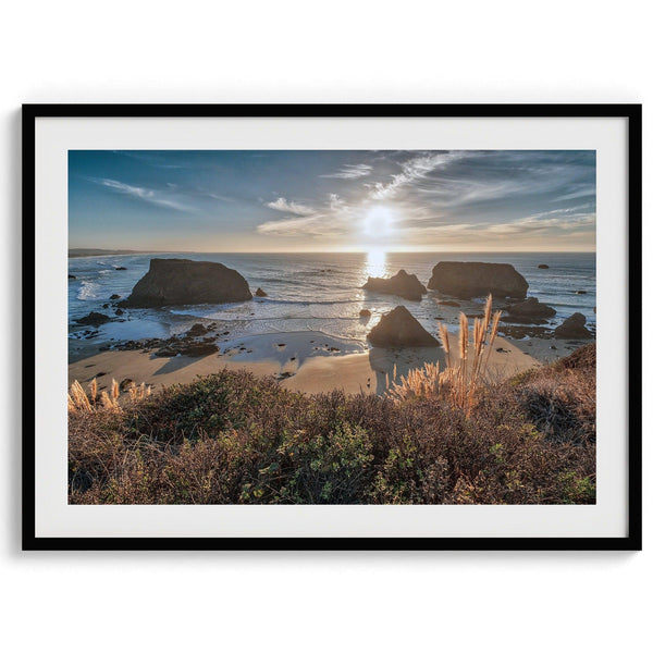 A fine art unframed or framed beach print showing the breathtaking beach of Fort Bragg, California, as the sunset ray of lights hits the ocean and the vast sea stacks.