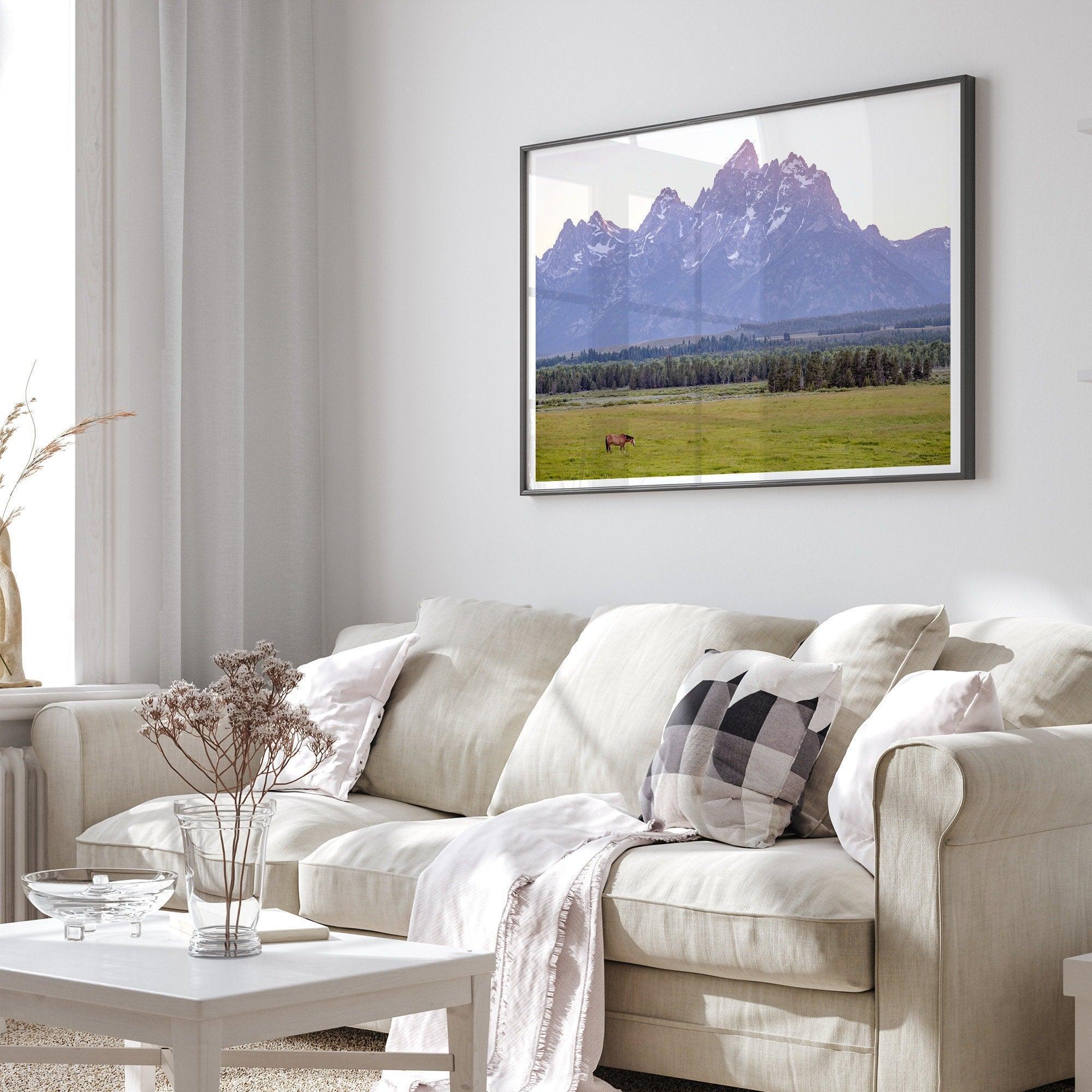 A stunning snow-covered mountain framed or unframed print from Grand Teton National Park with a beautiful horse grazing the grass in the forefront.