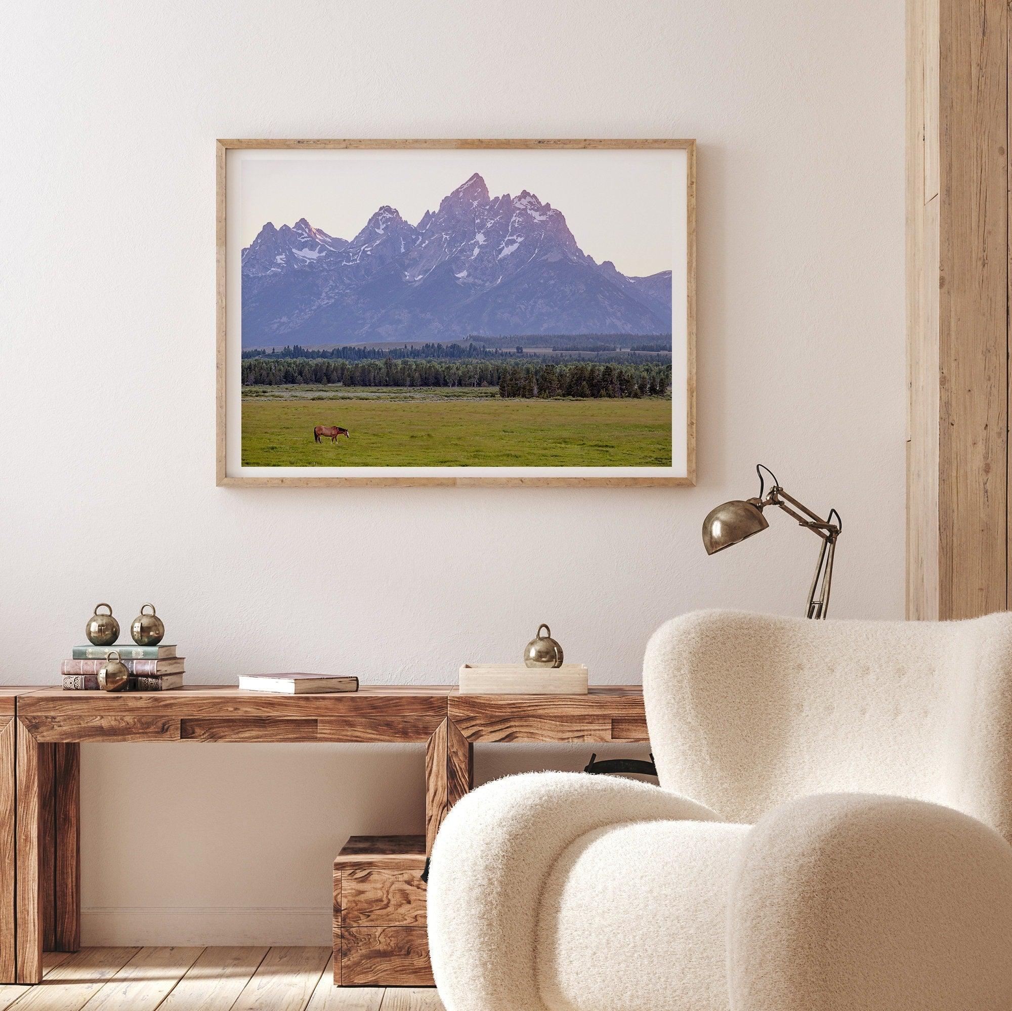 A stunning snow-covered mountain framed or unframed print from Grand Teton National Park with a beautiful horse grazing the grass in the forefront.