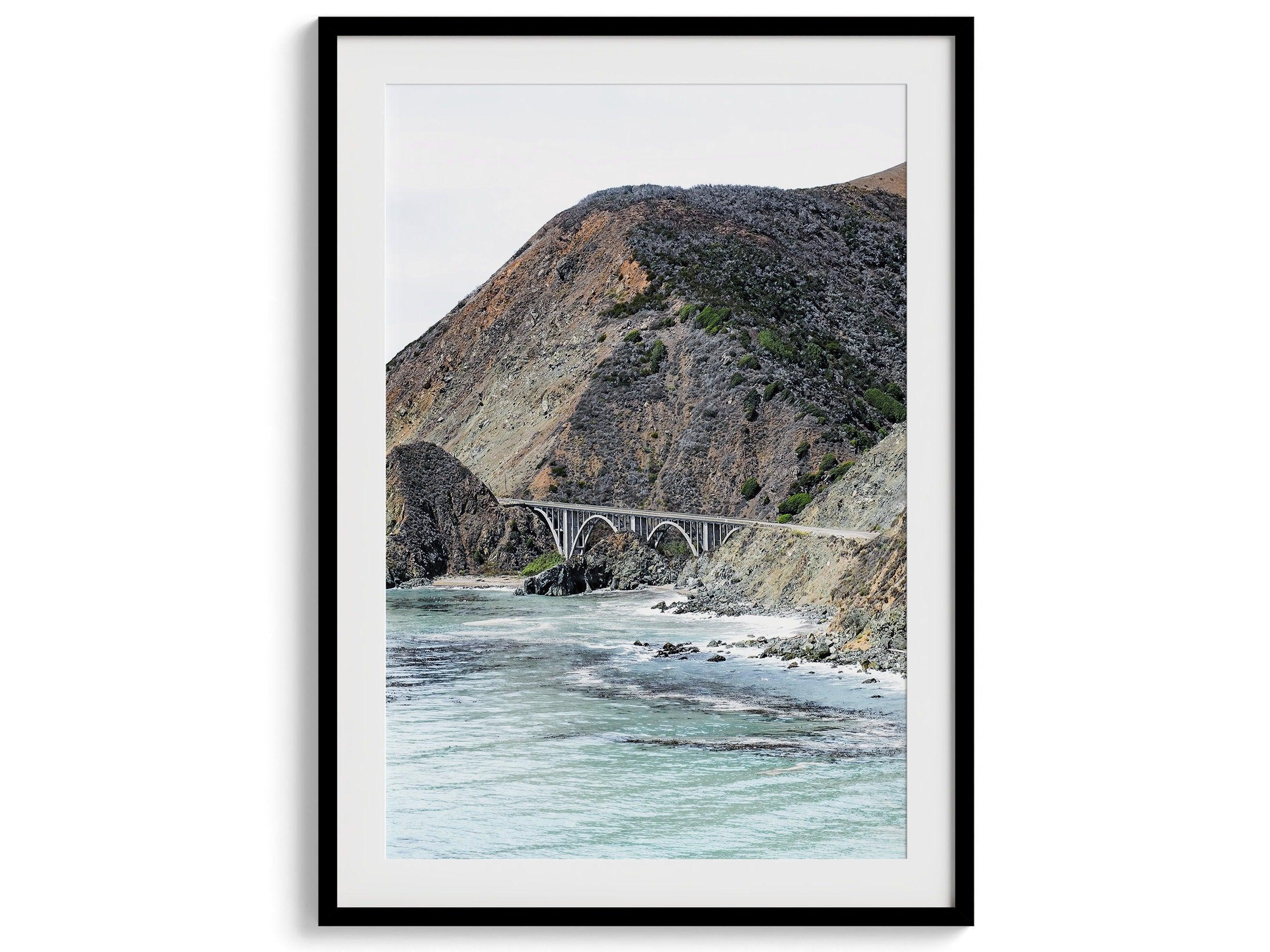 This California coastal print features the famous Bixby Bridge in Route 1, near Big Sur, In this Northwest Coast wall art you can see the ocean surf crashing against the coastal cliffs with the breathtaking old bridge in the center.