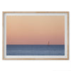 This stunning fine art ocean sunset photography print features a breathtaking scene of a boat against a golden and pink sky at sunset. The warm glow of the sunset and the natural beauty of the ocean and sky combine to create a soothing atmosphere.