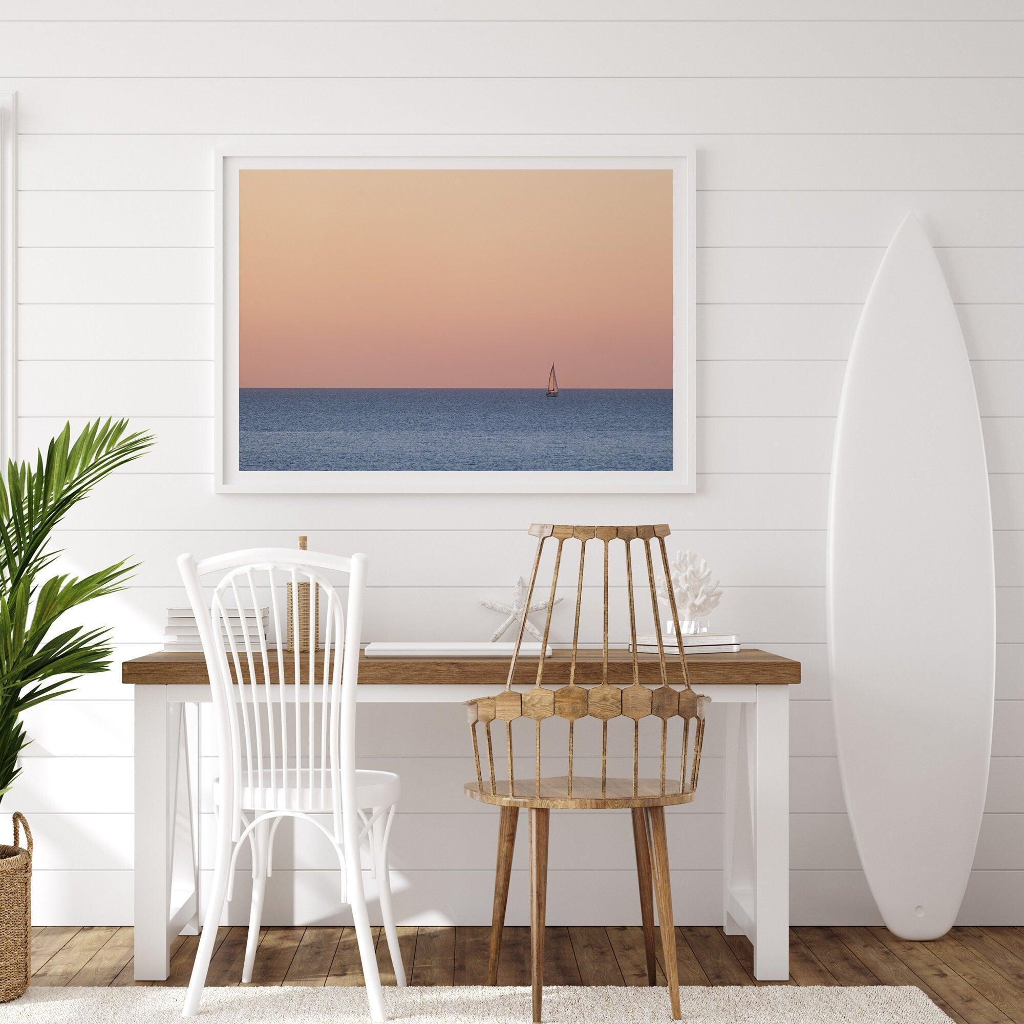 This stunning fine art ocean sunset photography print features a breathtaking scene of a boat against a golden and pink sky at sunset. The warm glow of the sunset and the natural beauty of the ocean and sky combine to create a soothing atmosphere.