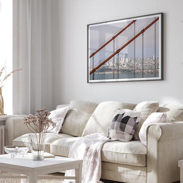 A fine art San Francisco print featuring the skyline of san Francisco through the wires of the famous golden gate bridge, offering a unique angle of the city and bridge.