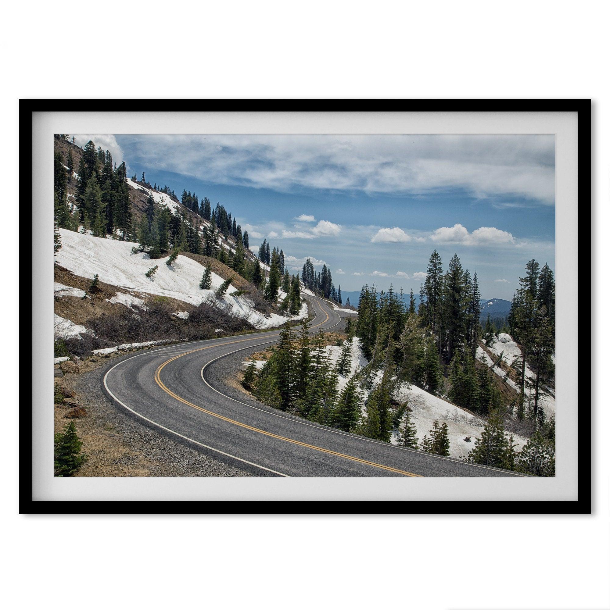 An unframed or framed fine art print of a mountain in Lassen National Park, Featuring a winding road through the lush forest and snow covered mountain.