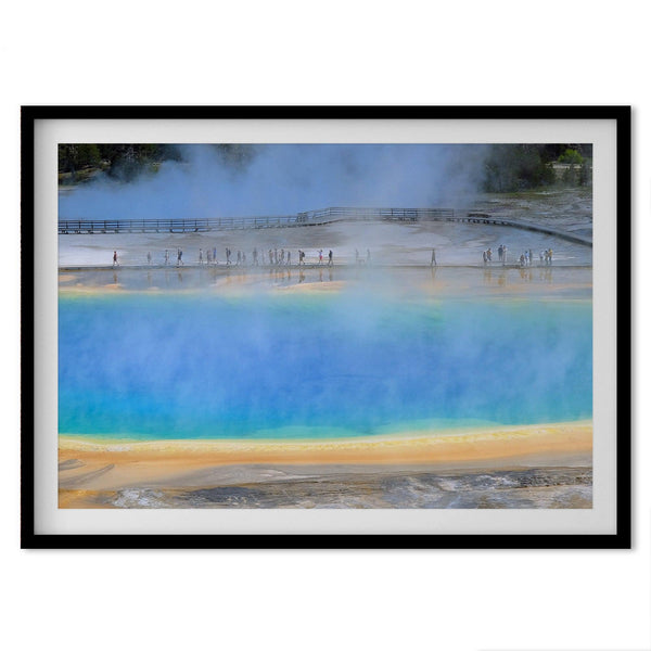 A fine art colorful photography print of Grand Prismatic Hot Springs in Yellowstone National Park. The picture shows the scale of the hot springs next to the people walking next to it.