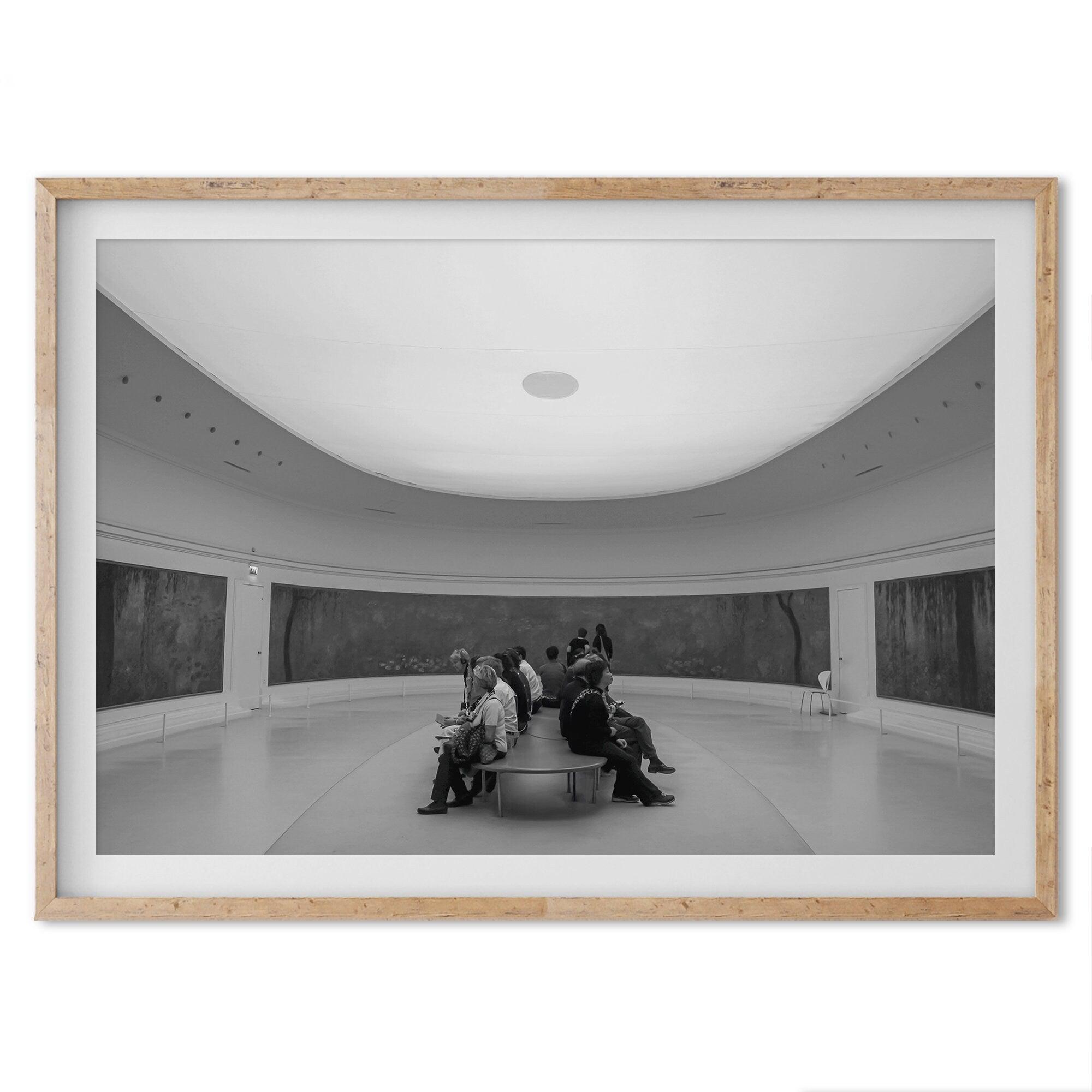 This unique black and white fine art Paris photo print transports you to the heart of the Musée d'Orsay in Paris, the center of the Impressionist movement. This Paris wall art showcases spectators sitting in the middle of the Monet exhibition.