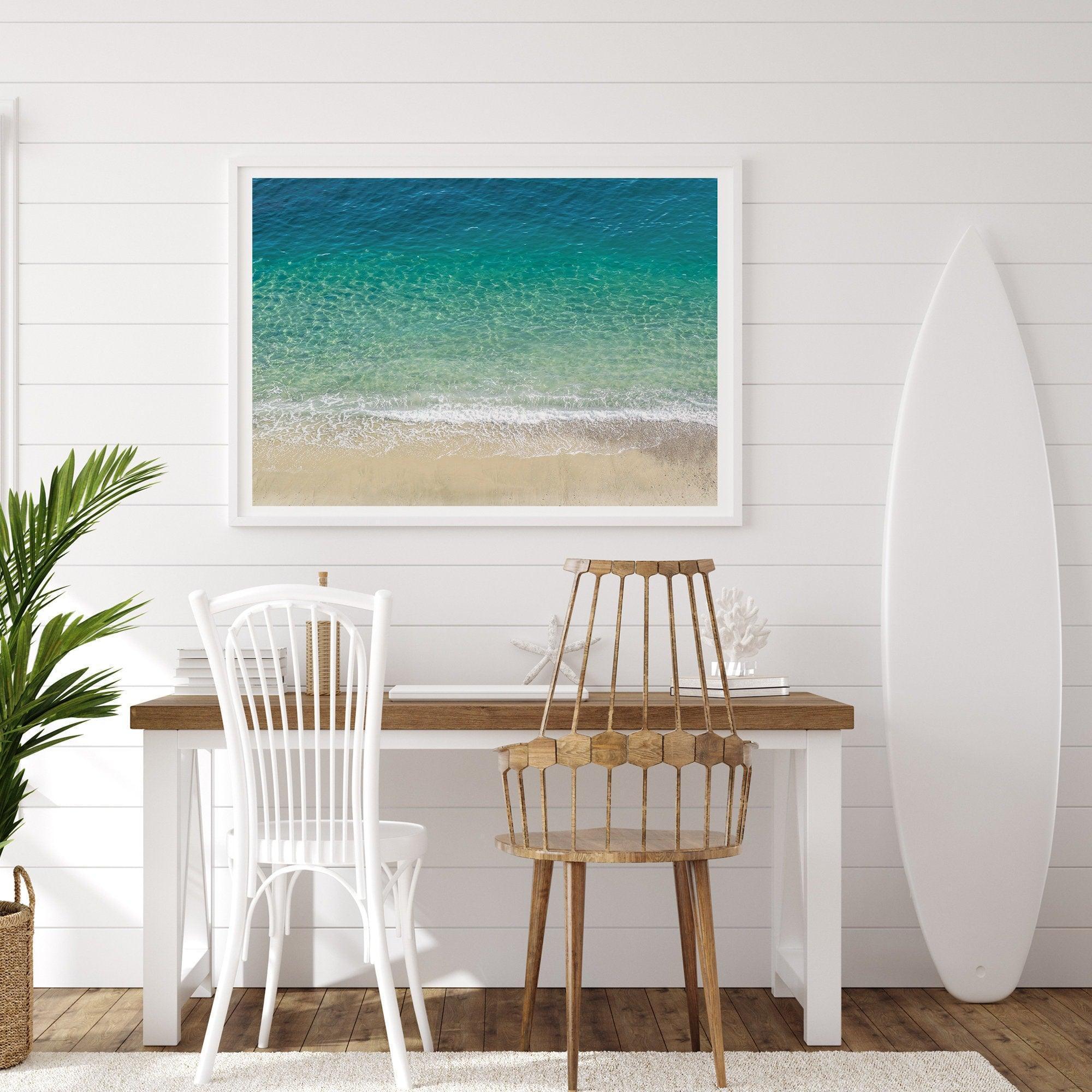 This fine art aerial beach print showcases the mesmerizing colors of the ocean in vivid detail. From the deep blue depths to the vibrant greenish turquoise blue, transitioning to the golden sandy beach and the crashing white surf.