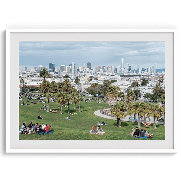 A fine art unframed or framed San Francisco print of Mission Dolores Park showcasing picnic blankets and people enjoying a quiet afternoon with the city skyline in the backdrop.