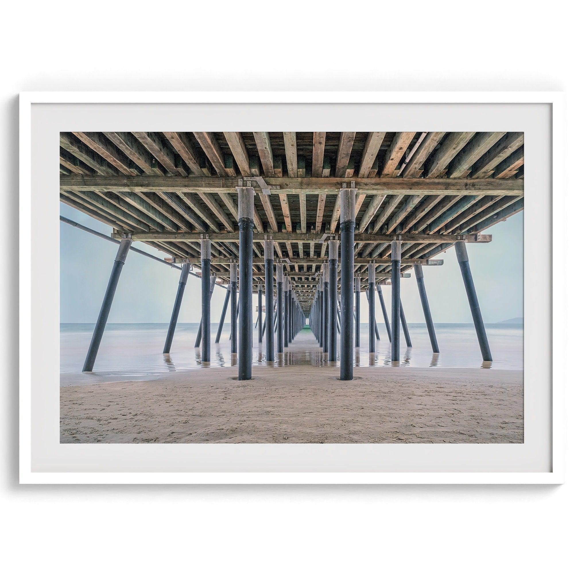 A fine art boho style beach photography print featuring a view from below Pismo Beach Pier.