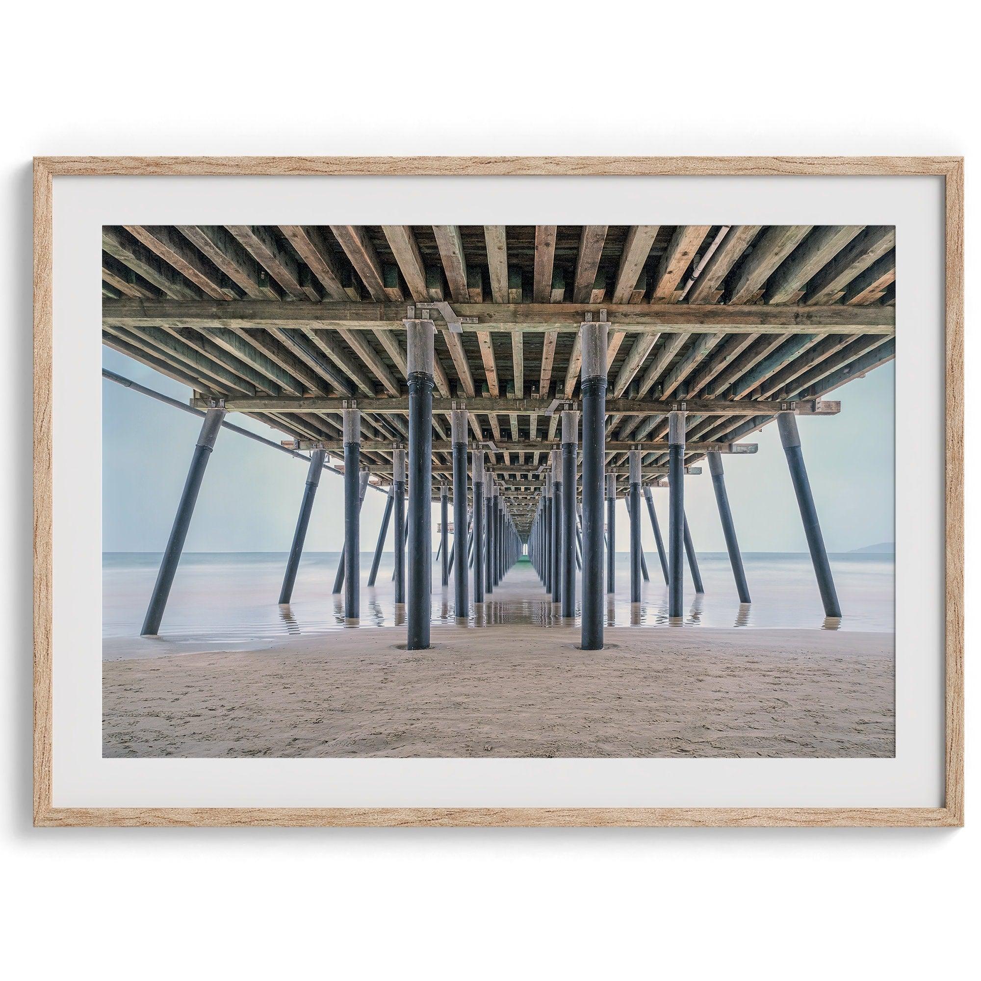 A fine art boho style beach photography print featuring a view from below Pismo Beach Pier.