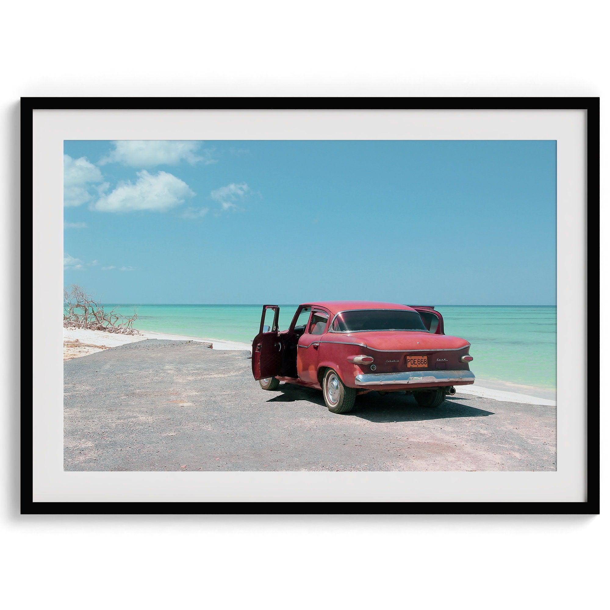 A fine art beach print with a vintage car in front of a turquoise ocean beach.