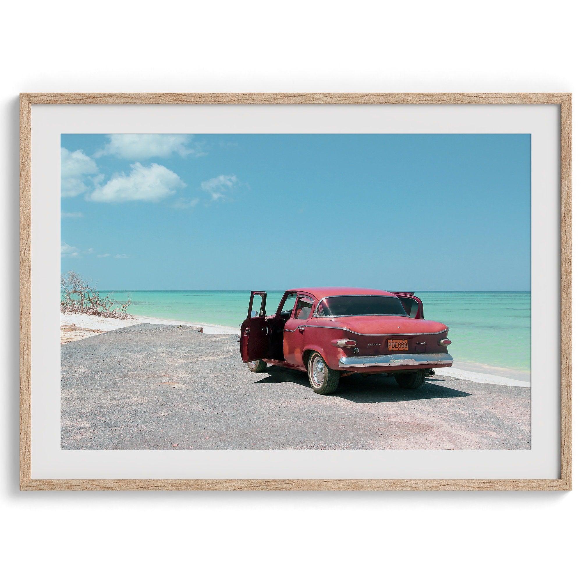 A fine art beach print with a vintage car in front of a turquoise ocean beach.