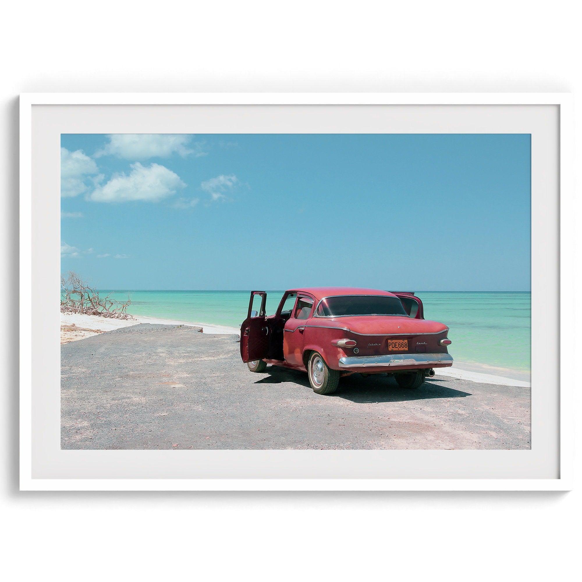 A fine art beach print with a vintage car in front of a turquoise ocean beach.