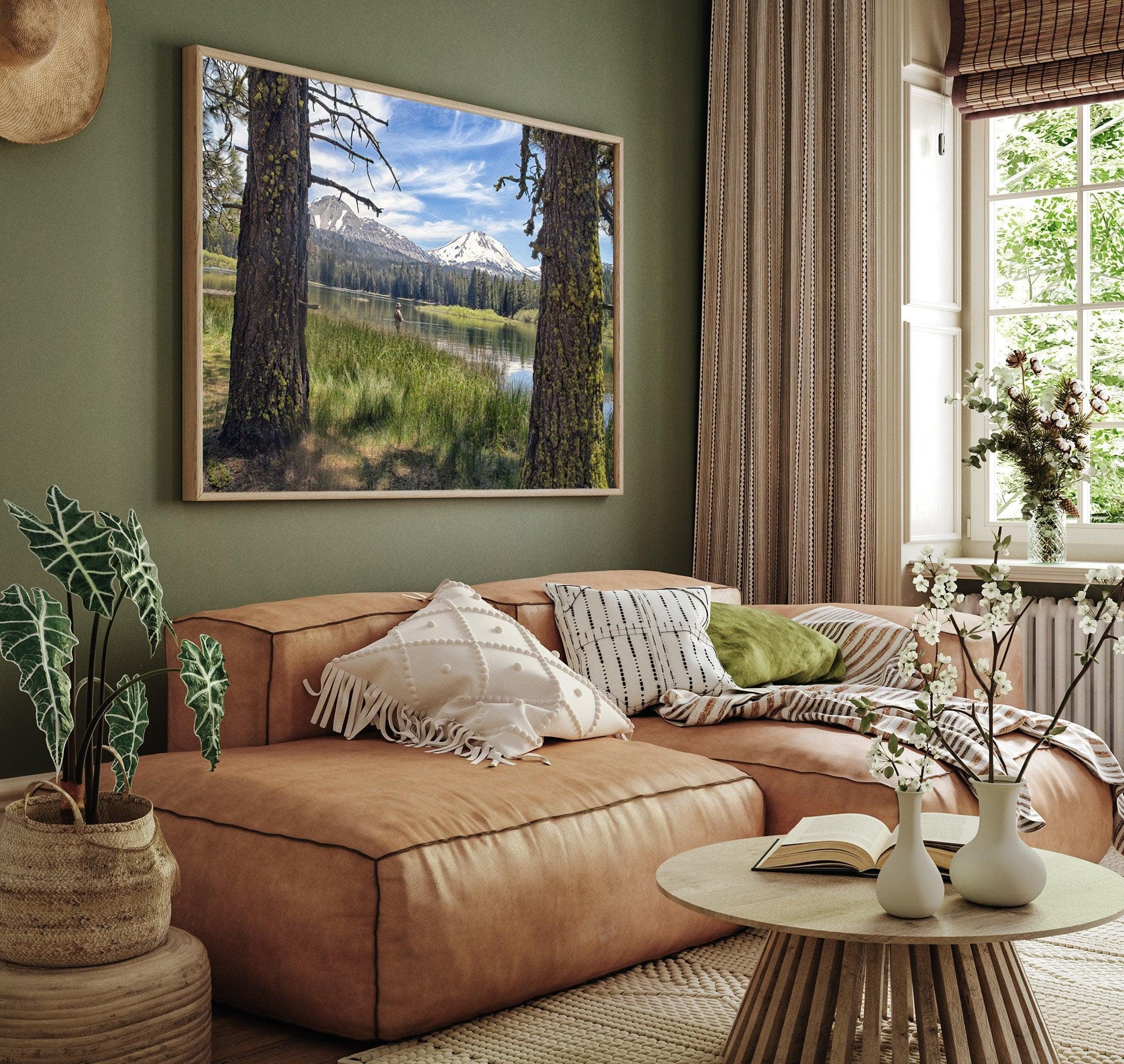 A stunning unframed or framed canvas print featuring a fisherman in Lassen National Park enjoying the tranquility of a serene lake nestled in the midst of towering snow-capped mountains.