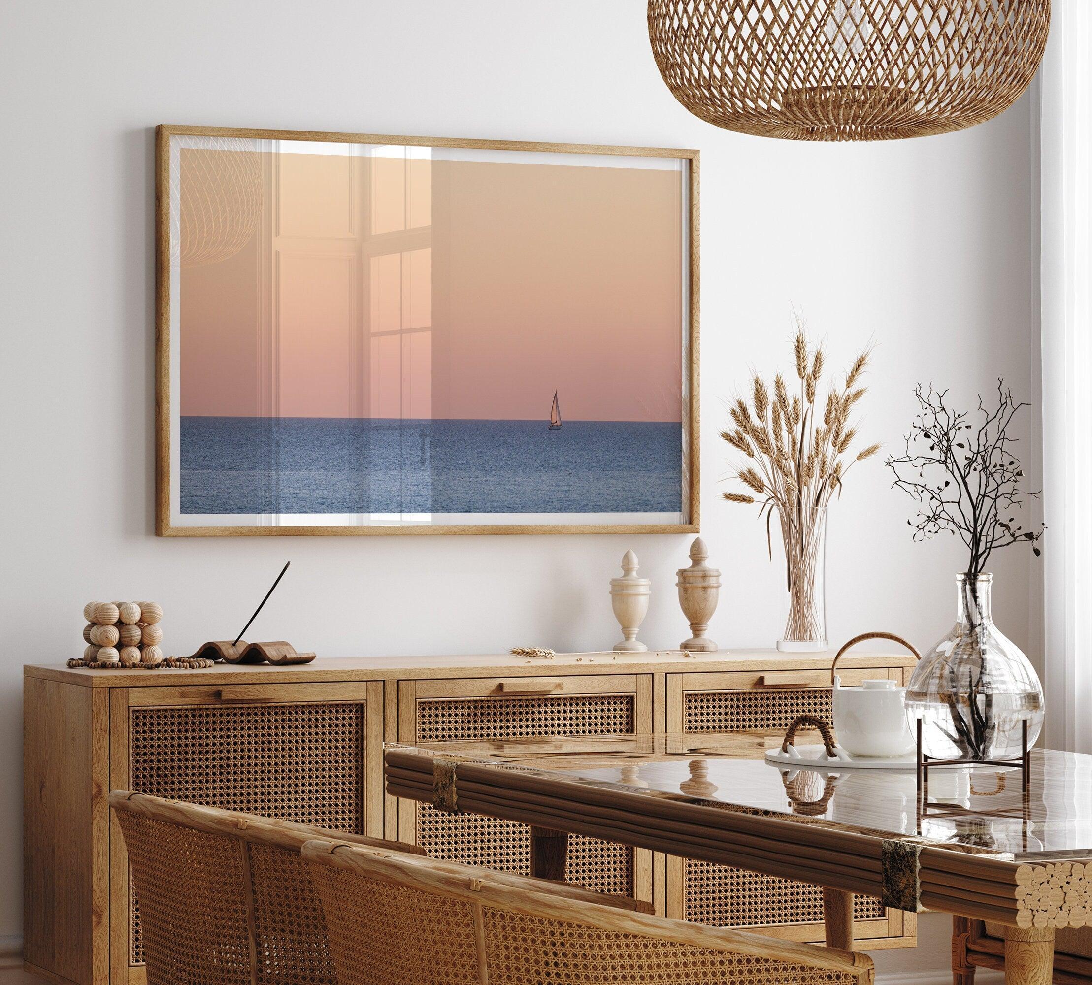 This stunning fine art ocean sunset photography print features a breathtaking scene of a boat against a golden and pink sky at sunset. The warm glow of the sunset and the natural beauty of the ocean and sky combine to create a soothing atmosphere.