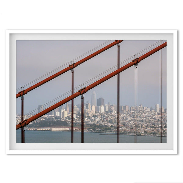A fine art San Francisco print featuring the skyline of san Francisco through the wires of the famous golden gate bridge, offering a unique angle of the city and bridge.