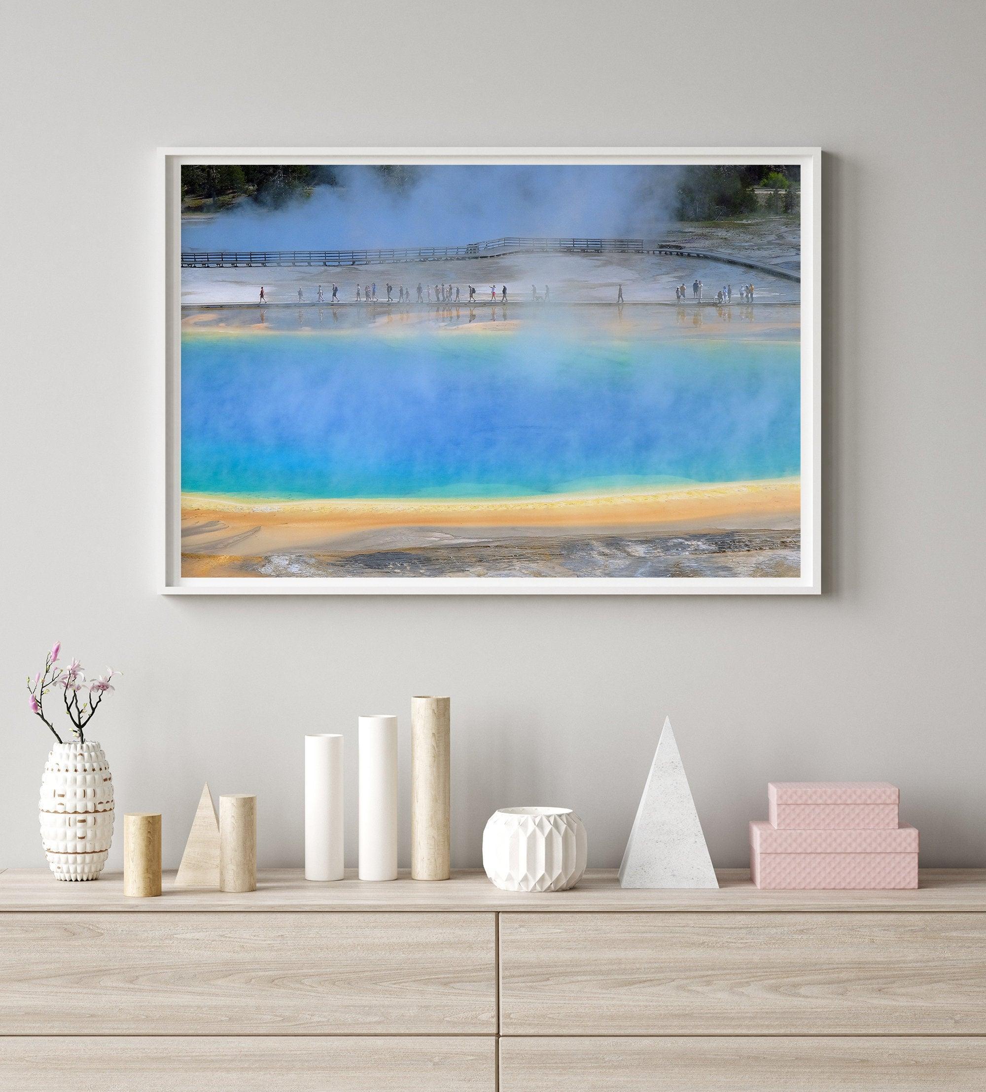 A fine art colorful photography print of Grand Prismatic Hot Springs in Yellowstone National Park. The picture shows the scale of the hot springs next to the people walking next to it.