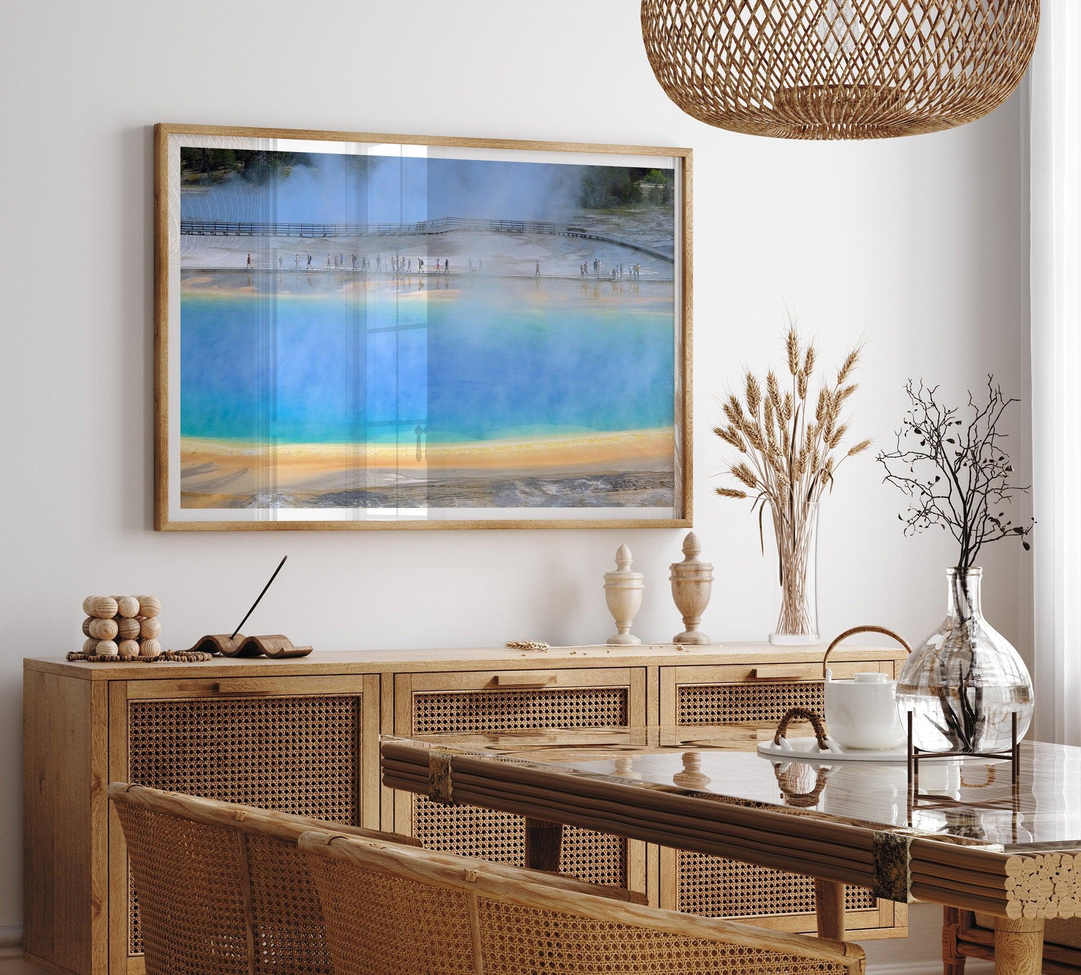 A fine art colorful photography print of Grand Prismatic Hot Springs in Yellowstone National Park. The picture shows the scale of the hot springs next to the people walking next to it.