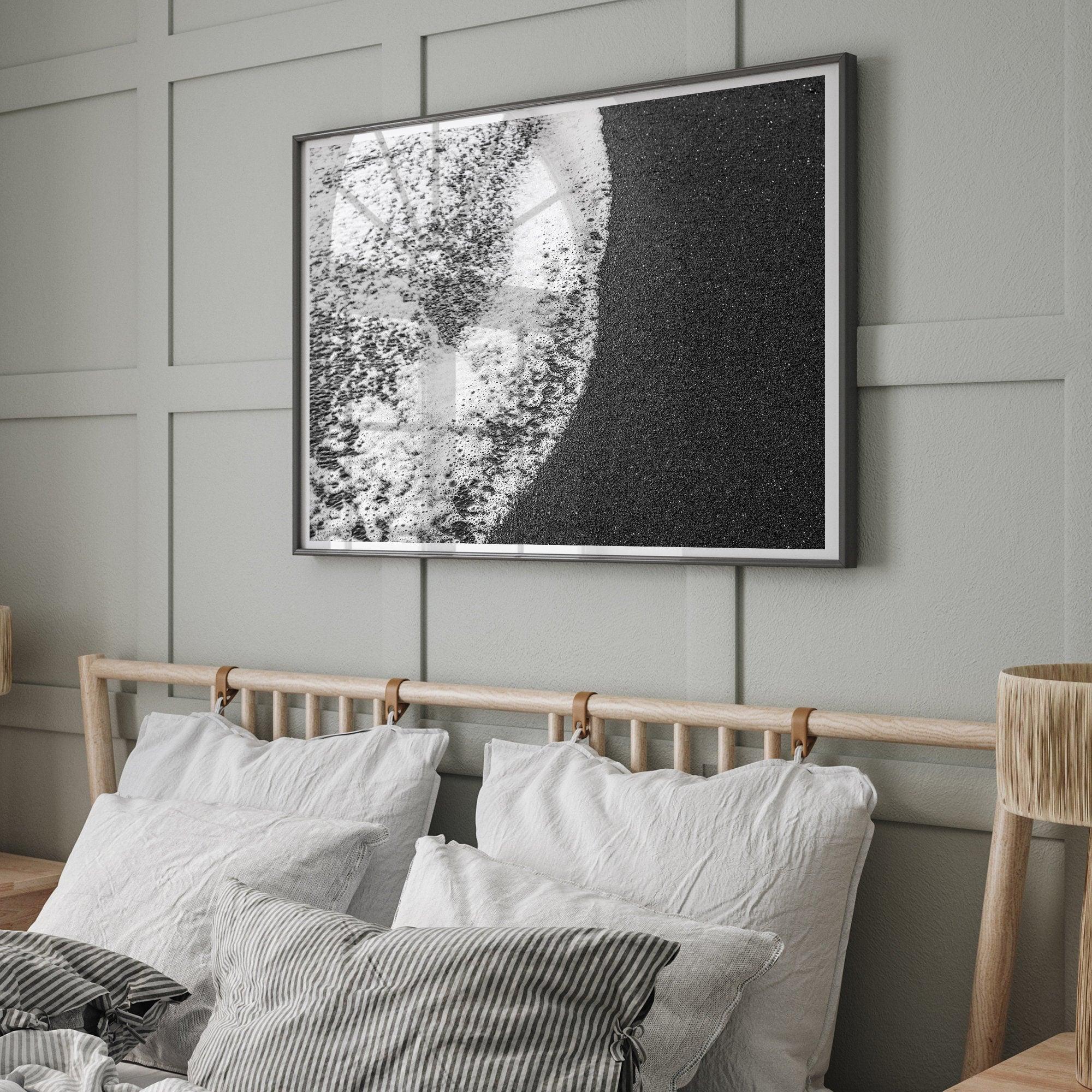 A minimalist fine art black and white beach print showing the ocean surf gently crashing onto a black sand beach in Maui, Hawaii.