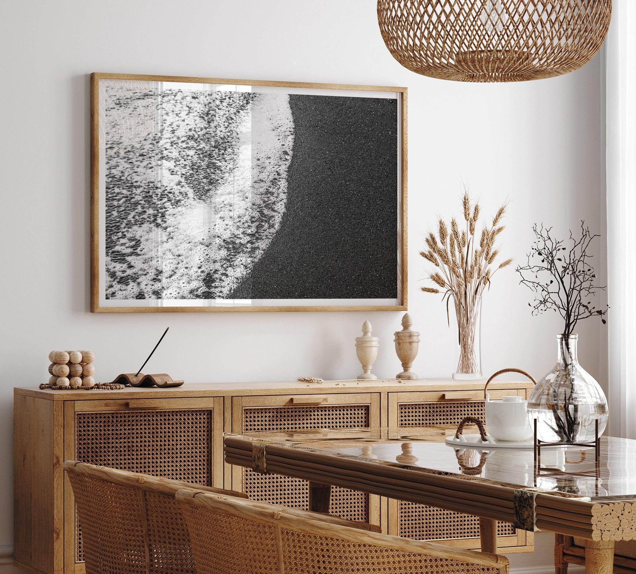 A minimalist fine art black and white beach print showing the ocean surf gently crashing onto a black sand beach in Maui, Hawaii.