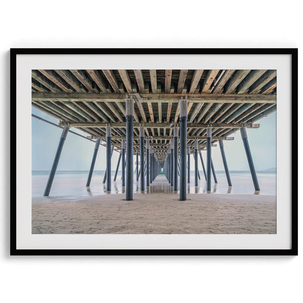 A fine art boho style beach photography print featuring a view from below Pismo Beach Pier.