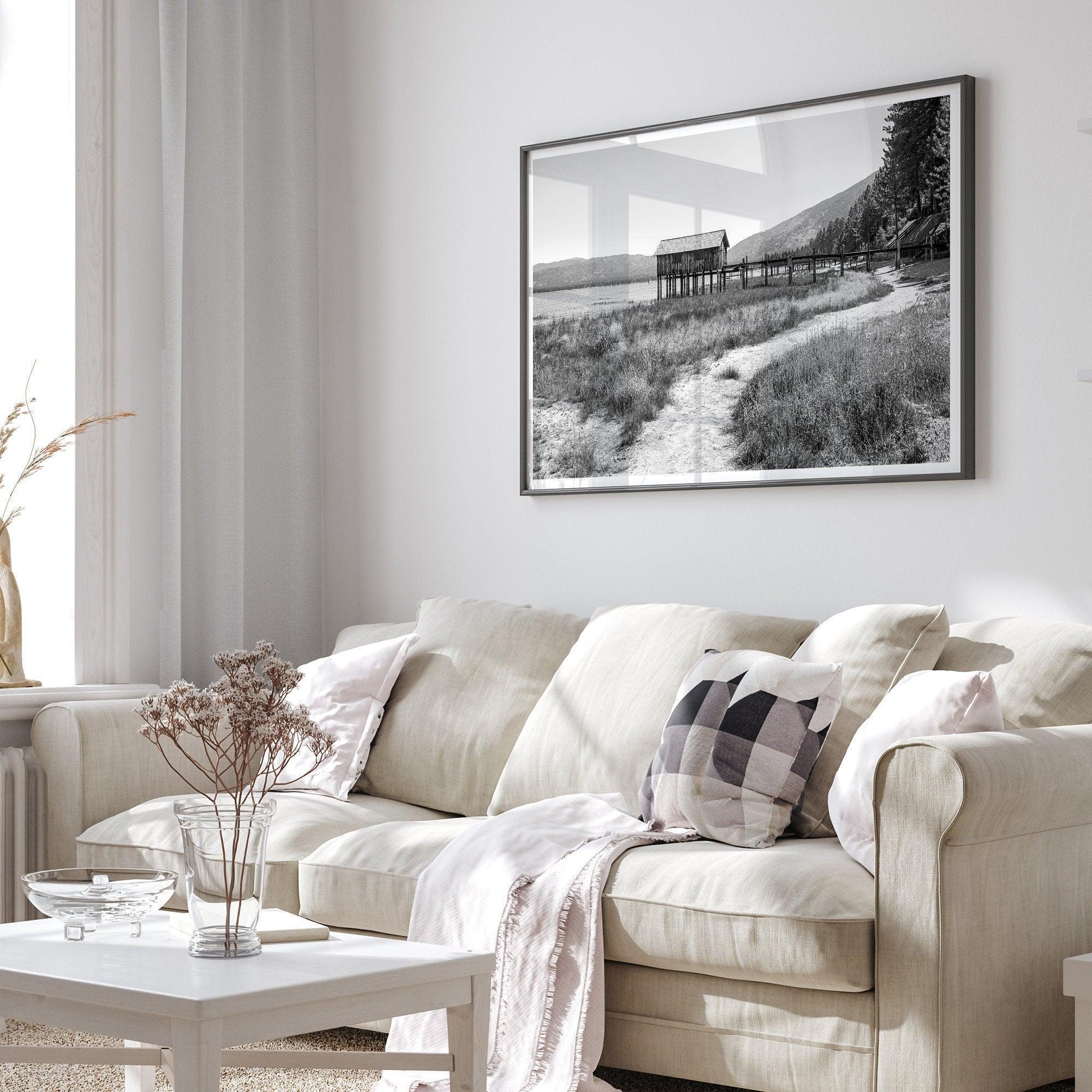 A fine art black and white vintage style framed photography print featuring a rustic old boathouse nested on a Lake Tahoe beach.