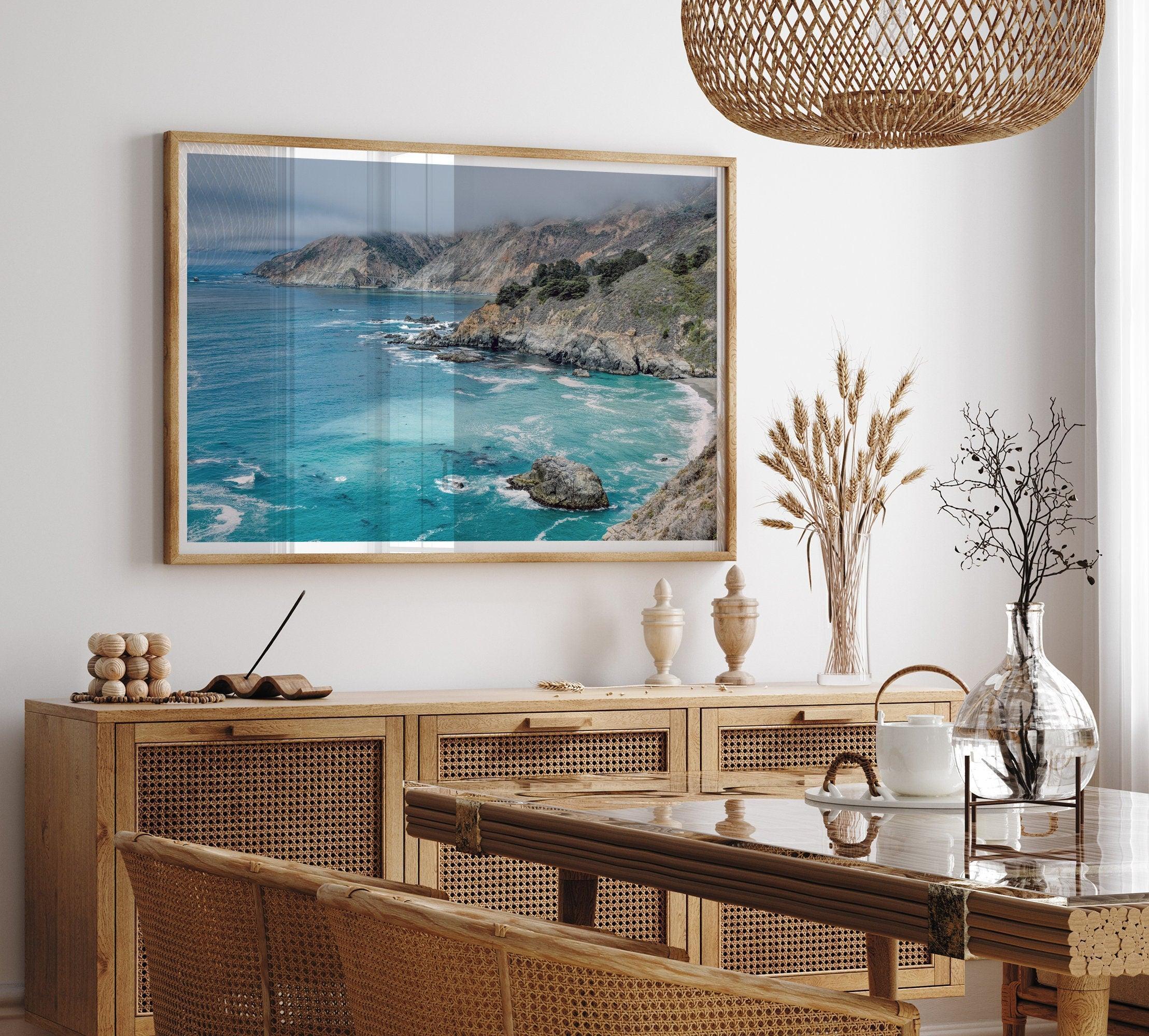 A fine art ocean print from Big Sur California featuring dramatic cliffs, the blue ocean and surf, and the Bixby bridge in the backdrop.