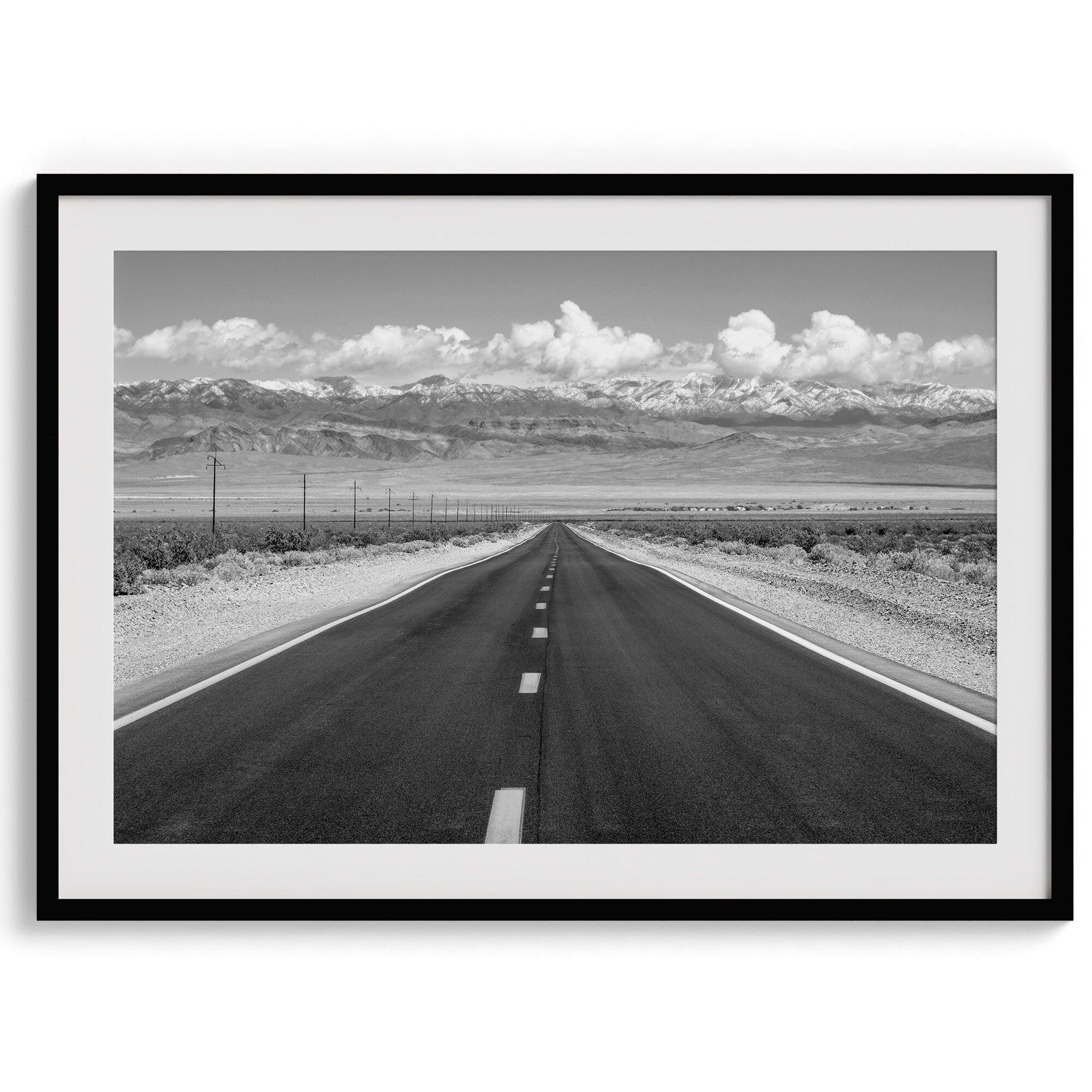 This stunning piece of black and white desert wall art will take your breath away. A beautifully framed picture of a Death Valley National Park road leading towards the snow-covered mountains at the end of the desert.